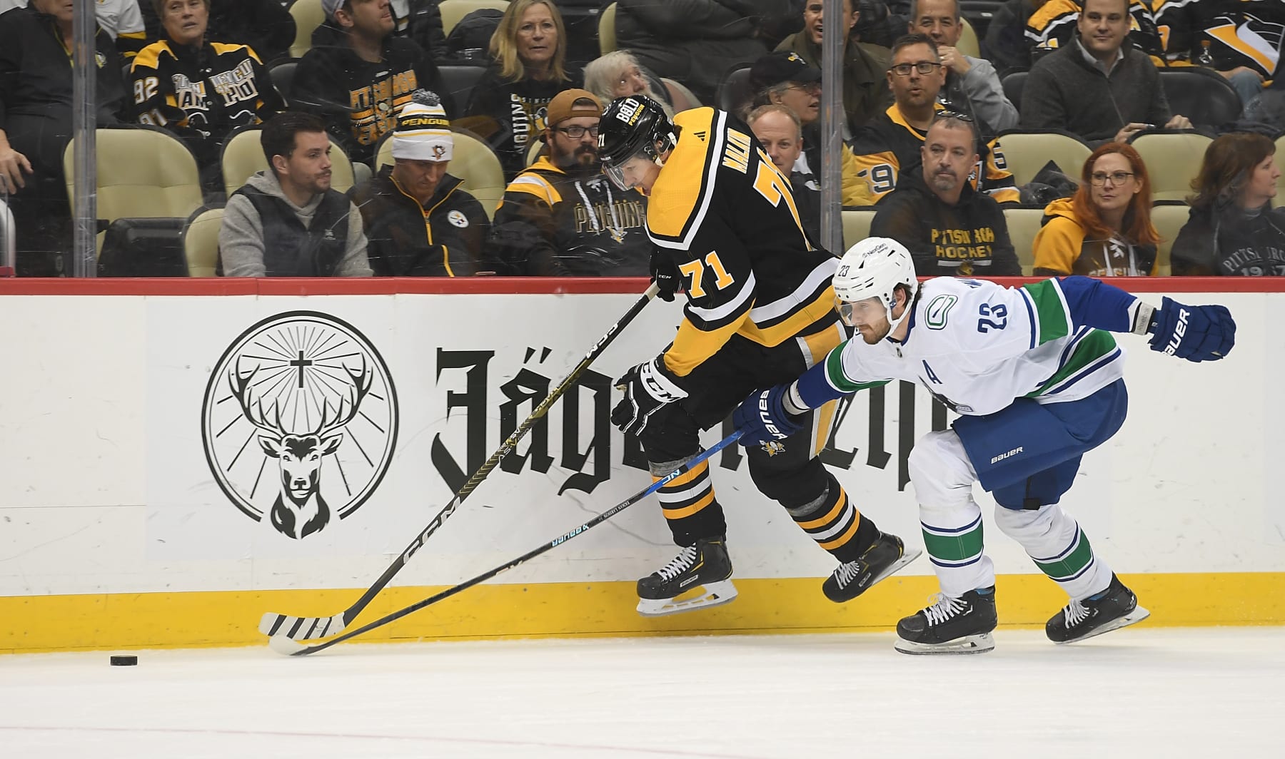 PITTSBURGH, PA - JANUARY 10: Evgeni Malkin #71 of the Pittsburgh Penguins skates the puck along the boards against Oliver Ekman-Larsson #23 of the Vancouver Canucks in the first period at PPG PAINTS Arena on January 10, 2023 in Pittsburgh, Pennsylvania. (Photo by Justin Berl/Getty Images)