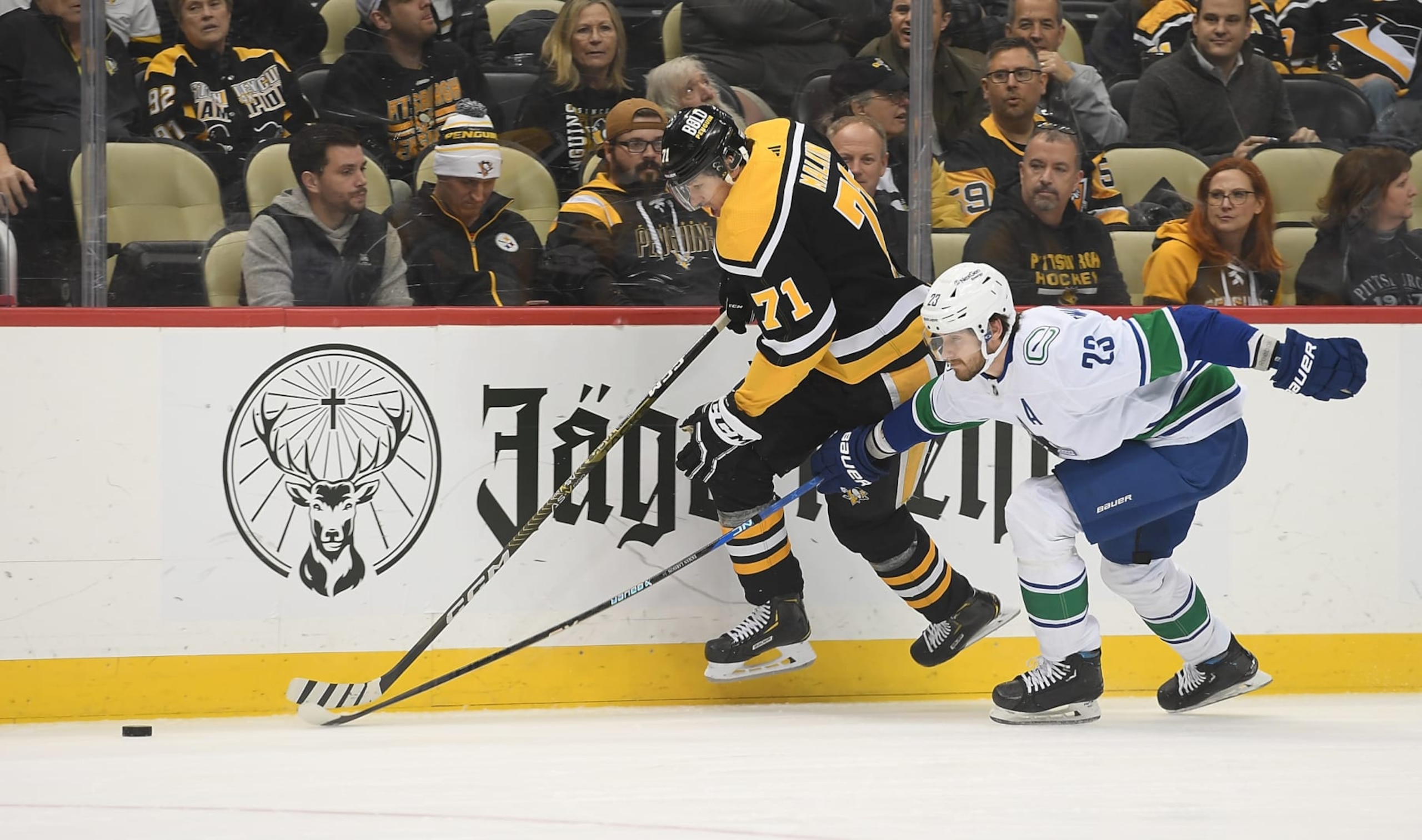 PITTSBURGH, PA - JANUARY 10: Evgeni Malkin #71 of the Pittsburgh Penguins skates the puck along the boards against Oliver Ekman-Larsson #23 of the Vancouver Canucks in the first period at PPG PAINTS Arena on January 10, 2023 in Pittsburgh, Pennsylvania. (Photo by Justin Berl/Getty Images)