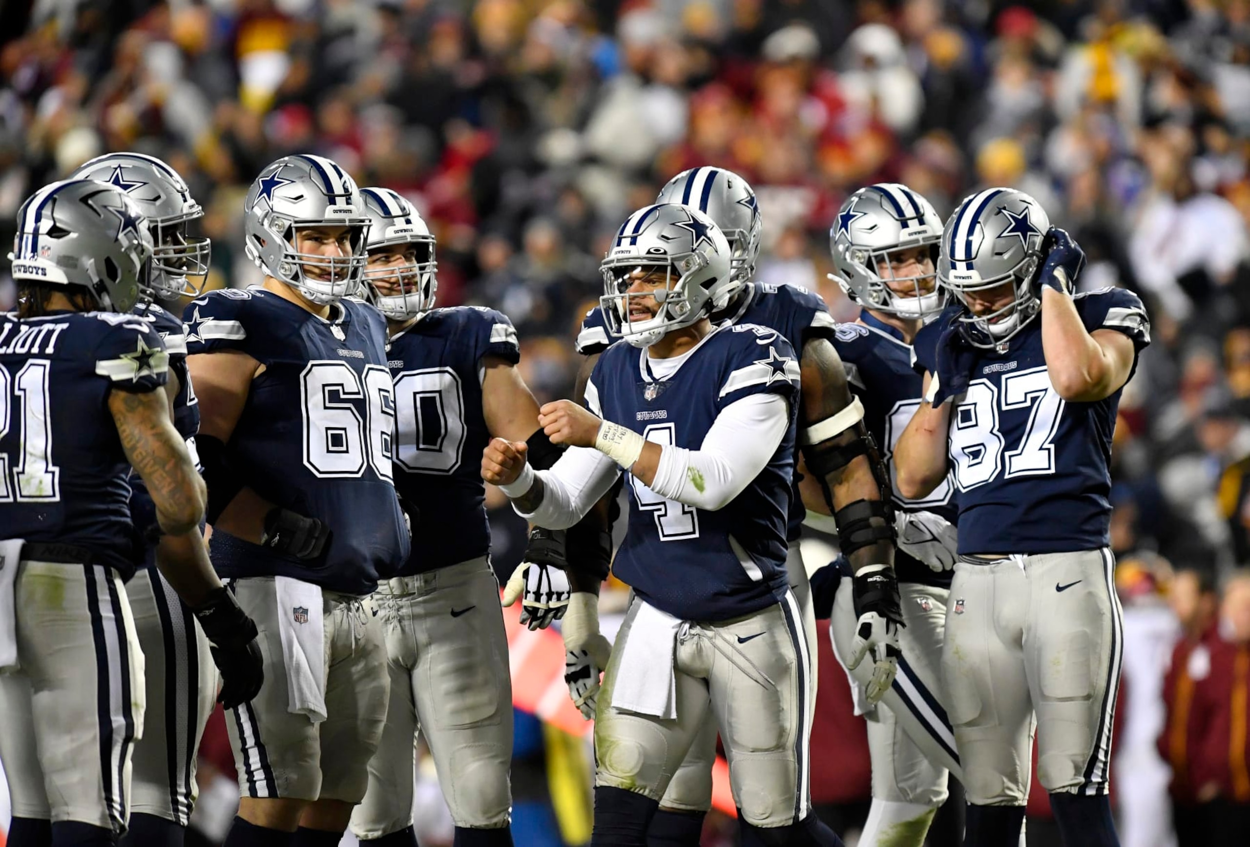 LANDOVER, MD - JANUARY 08: Cowboys quarterback Dak Prescott (4) fist bumps teammates in the offensive huddle during the Dallas Cowboys versus Washington Commanders National Football League game at FedEx Field on January 8, 2023 in Landover, MD. (Photo by Randy Litzinger/Icon Sportswire via Getty Images)