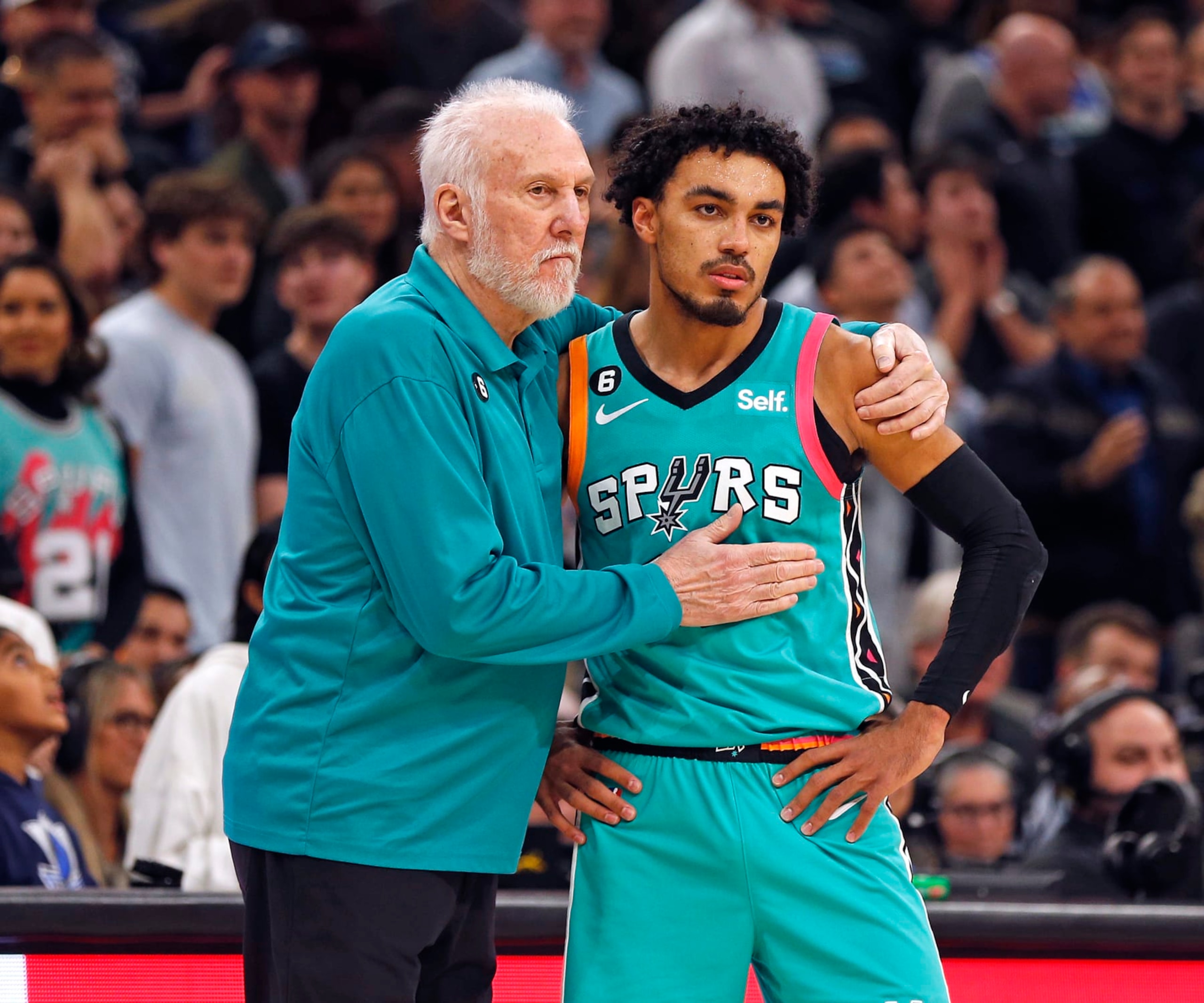 SAN ANTONIO, TX - DECEMBER 31:  Tre Jones #33 of the San Antonio Spurs is consoled by head coach Gregg Popovich after missing a foul shot that would have tied the game late in the second half against the Dallas Mavericks at AT&T Center on December 31, 2022 in San Antonio, Texas. NOTE TO USER: User expressly acknowledges and agrees that, by downloading and or using this photograph, User is consenting to terms and conditions of the Getty Images License Agreement. (Photo by Ronald Cortes/Getty Images)