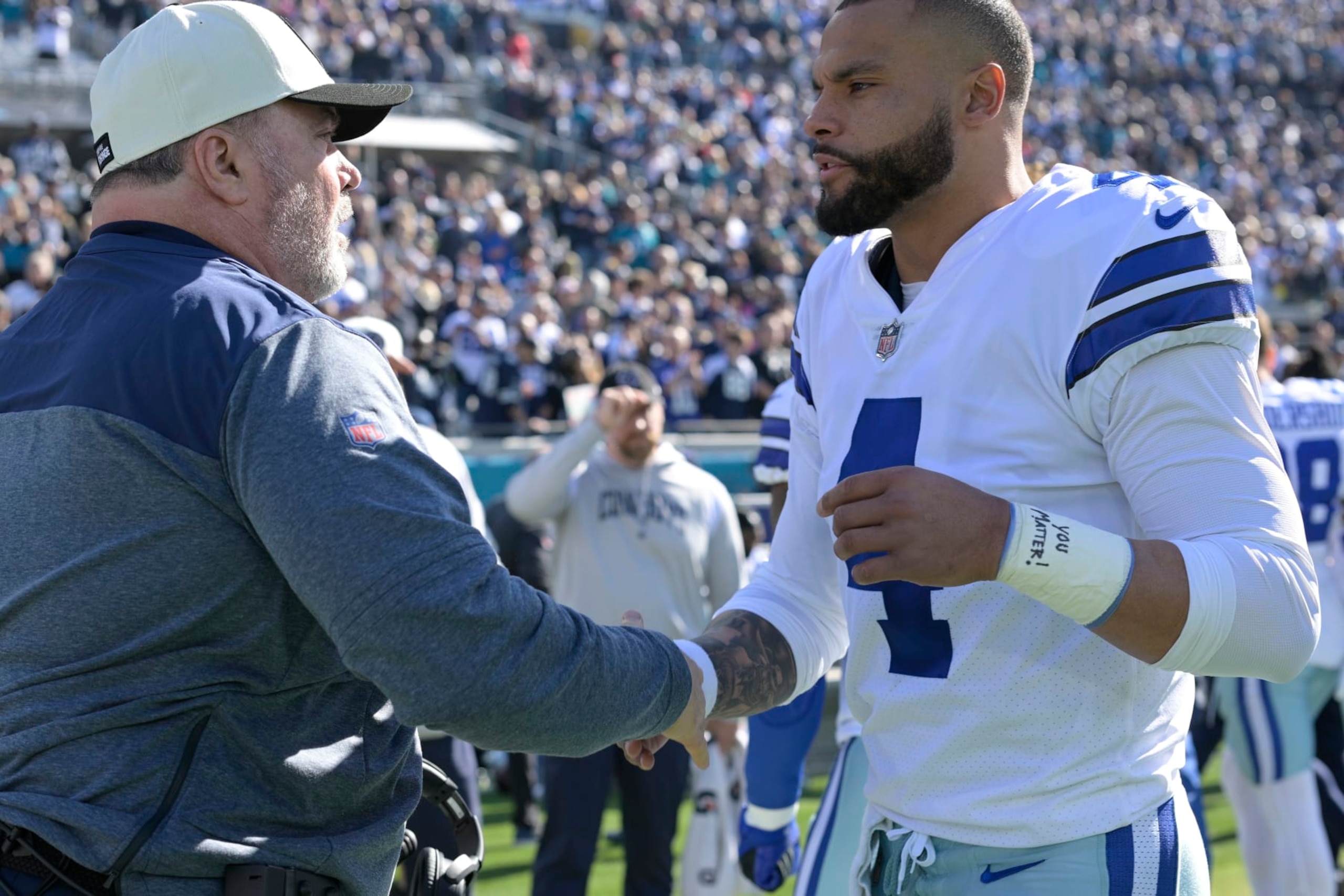 Dallas Cowboys head coach Mike McCarthy, left, and quarterback Dak Prescott (4) shake hands prior to the start of an NFL football game against the Jacksonville Jaguars, Sunday, Dec. 18, 2022, in Jacksonville, Fla. (AP Photo/Phelan M. Ebenhack)