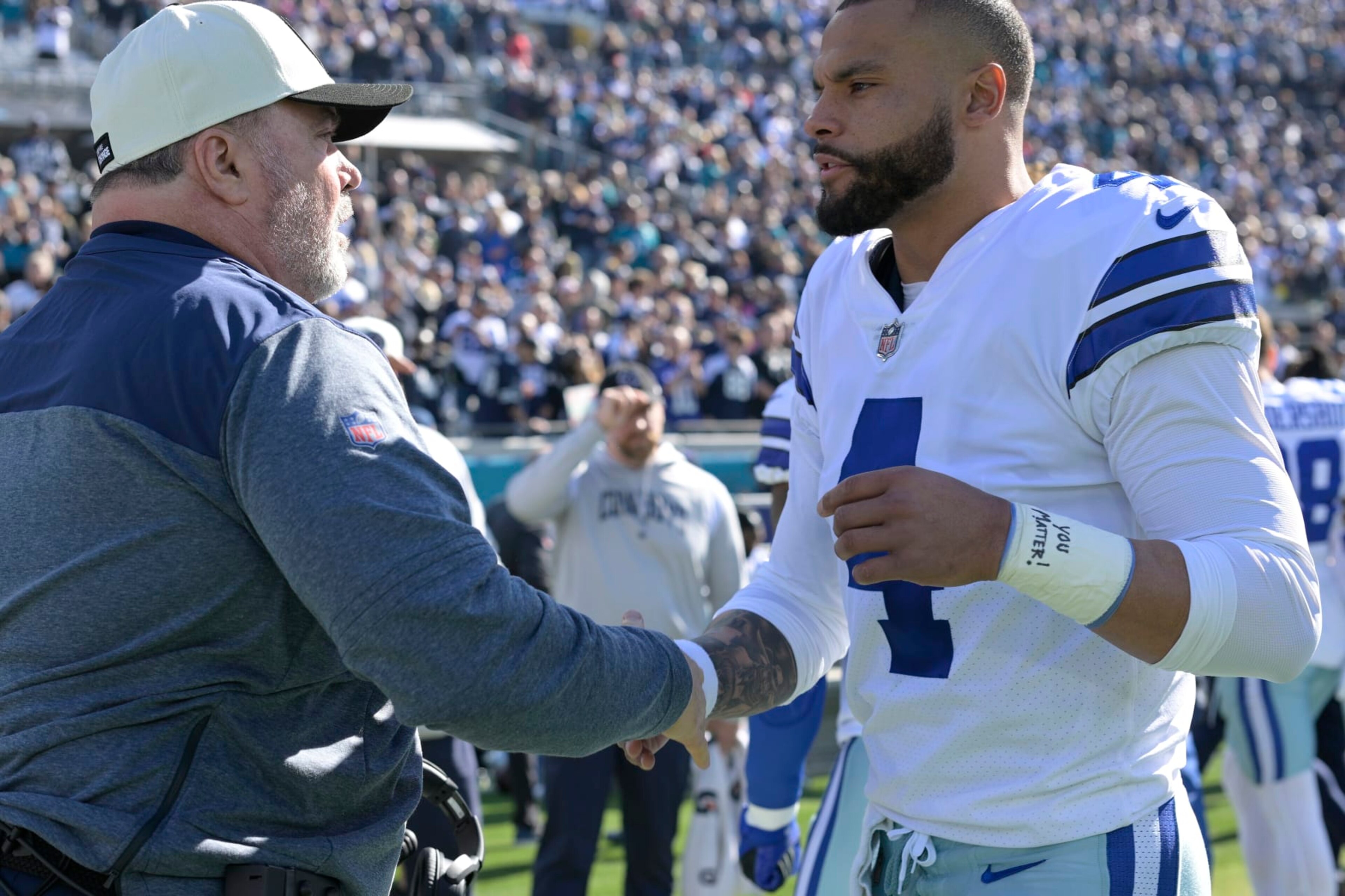 Dallas Cowboys head coach Mike McCarthy, left, and quarterback Dak Prescott (4) shake hands prior to the start of an NFL football game against the Jacksonville Jaguars, Sunday, Dec. 18, 2022, in Jacksonville, Fla. (AP Photo/Phelan M. Ebenhack)
