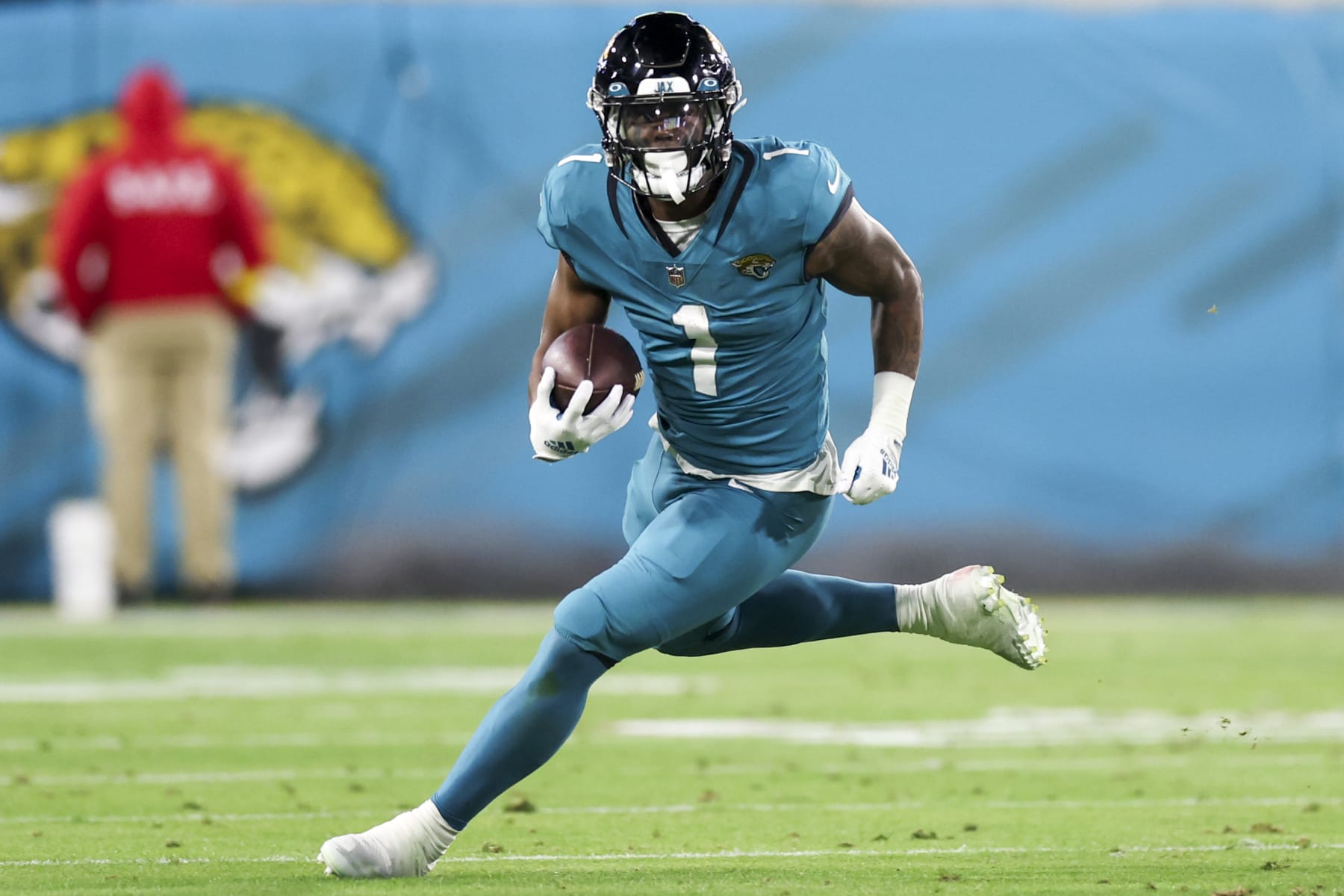 JACKSONVILLE, FLORIDA - JANUARY 07: Travis Etienne Jr. #1 of the Jacksonville Jaguars runs the ball during the second quarter against the Tennessee Titans at TIAA Bank Field on January 07, 2023 in Jacksonville, Florida. (Photo by Mike Carlson/Getty Images)