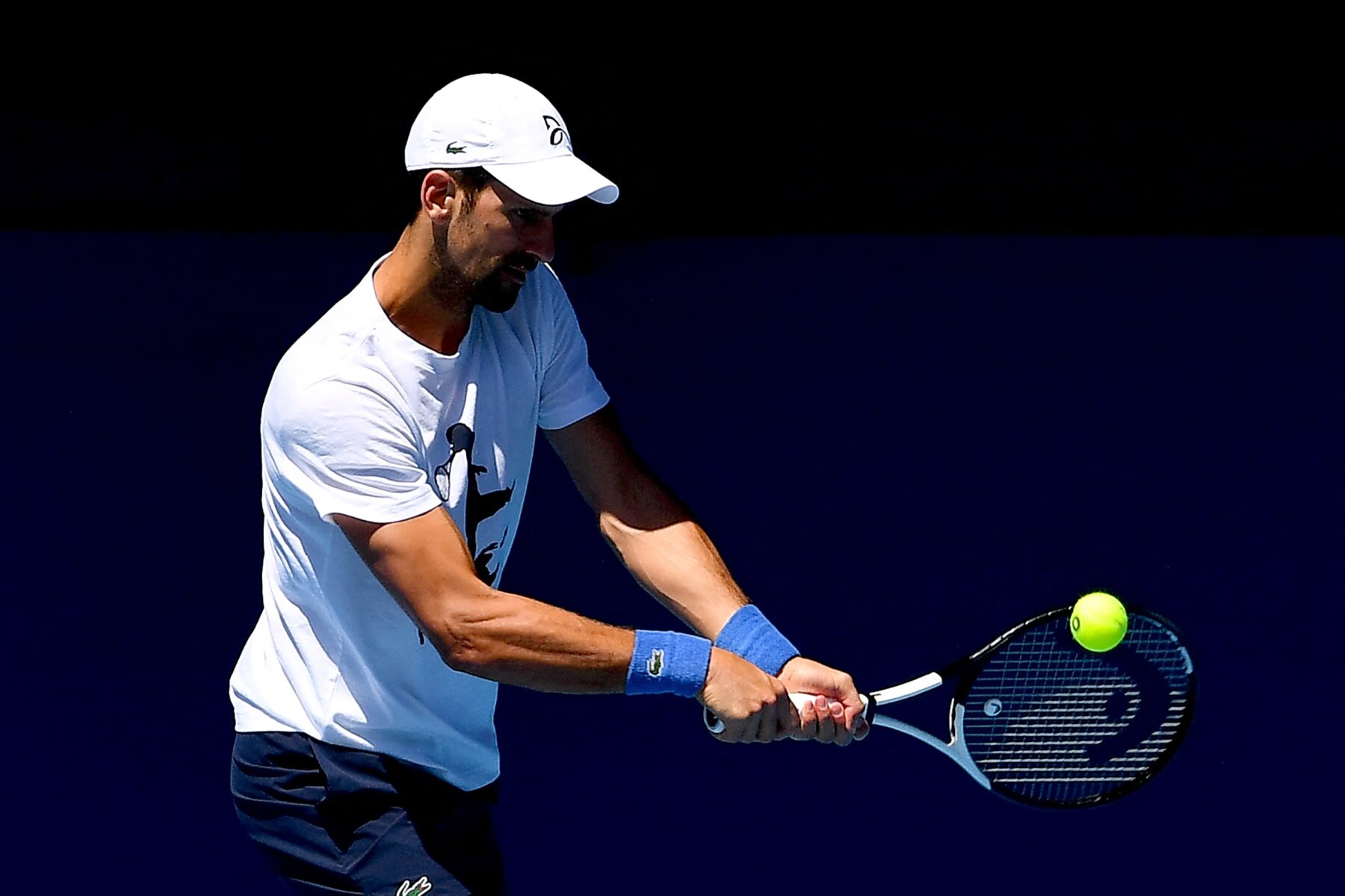 Serbia's Novak Djokovic hits a return during a practice session ahead of the Australian Open tennis tournament in Melbourne on January 14, 2023. - --IMAGE RESTRICTED TO EDITORIAL USE - STRICTLY NO COMMERCIAL USE-- (Photo by Paul CROCK / AFP) / --IMAGE RESTRICTED TO EDITORIAL USE - STRICTLY NO COMMERCIAL USE-- (Photo by PAUL CROCK/AFP via Getty Images)