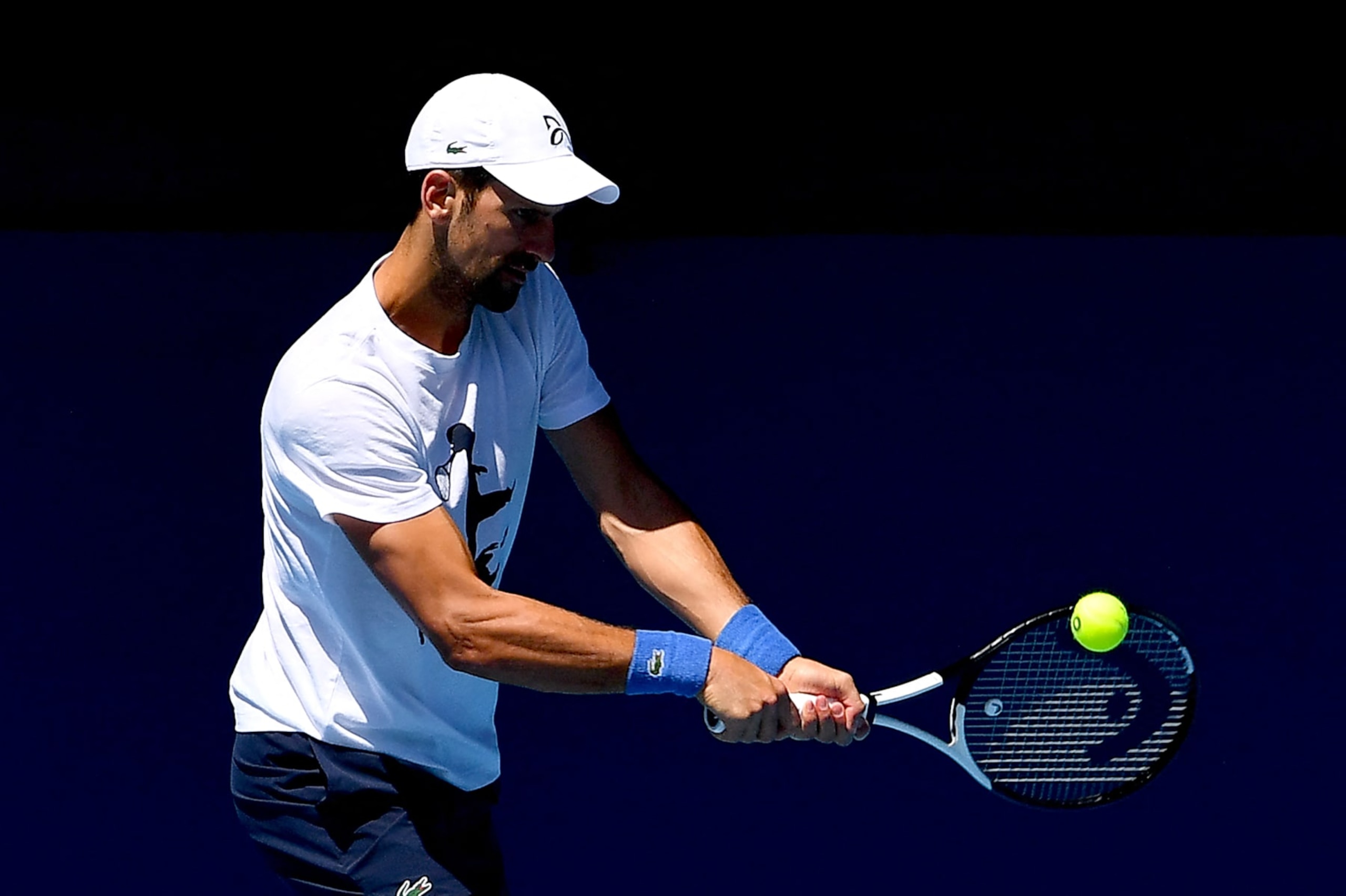 Serbia's Novak Djokovic hits a return during a practice session ahead of the Australian Open tennis tournament in Melbourne on January 14, 2023. - --IMAGE RESTRICTED TO EDITORIAL USE - STRICTLY NO COMMERCIAL USE-- (Photo by Paul CROCK / AFP) / --IMAGE RESTRICTED TO EDITORIAL USE - STRICTLY NO COMMERCIAL USE-- (Photo by PAUL CROCK/AFP via Getty Images) Serbia's Novak Djokovic hits a return during a practice session ahead of the Australian Open tennis tournament in Melbourne on January 14, 2023. - --IMAGE RESTRICTED TO EDITORIAL USE - STRICTLY NO COMMERCIAL USE-- (Photo by Paul CROCK / AFP) / --IMAGE RESTRICTED TO EDITORIAL USE - STRICTLY NO COMMERCIAL USE-- (Photo by PAUL CROCK/AFP via Getty Images)