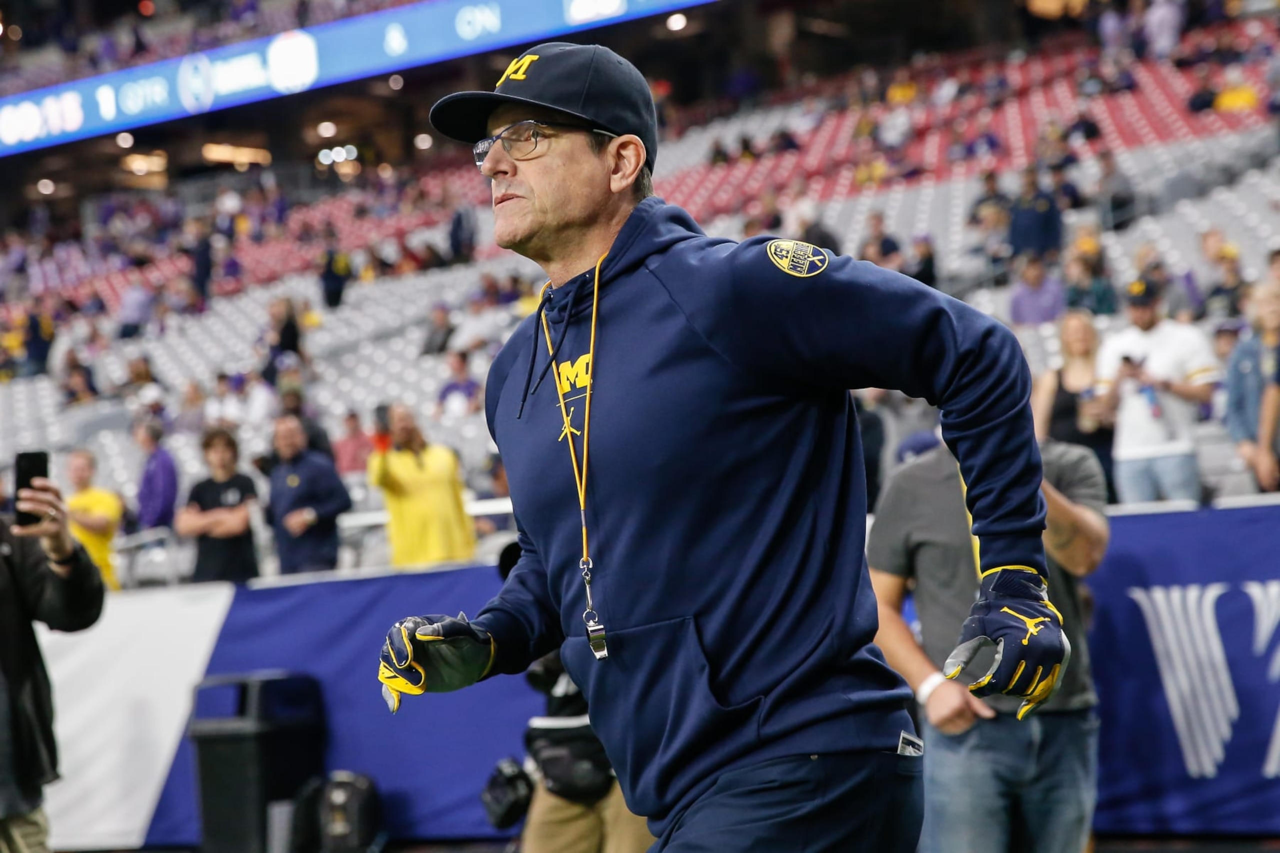 GLENDALE, AZ - DECEMBER 31: Michigan Wolverines head coach Jim Harbaugh runs onto the field before the VRBO Fiesta Bowl college football national championship semifinal game between the Michigan Wolverines and the TCU Horned Frogs on December 31, 2022 at State Farm Stadium in Glendale, Arizona. (Photo by Kevin Abele/Icon Sportswire via Getty Images) GLENDALE, AZ - DECEMBER 31: Michigan Wolverines head coach Jim Harbaugh runs onto the field before the VRBO Fiesta Bowl college football national championship semifinal game between the Michigan Wolverines and the TCU Horned Frogs on December 31, 2022 at State Farm Stadium in Glendale, Arizona. (Photo by Kevin Abele/Icon Sportswire via Getty Images)