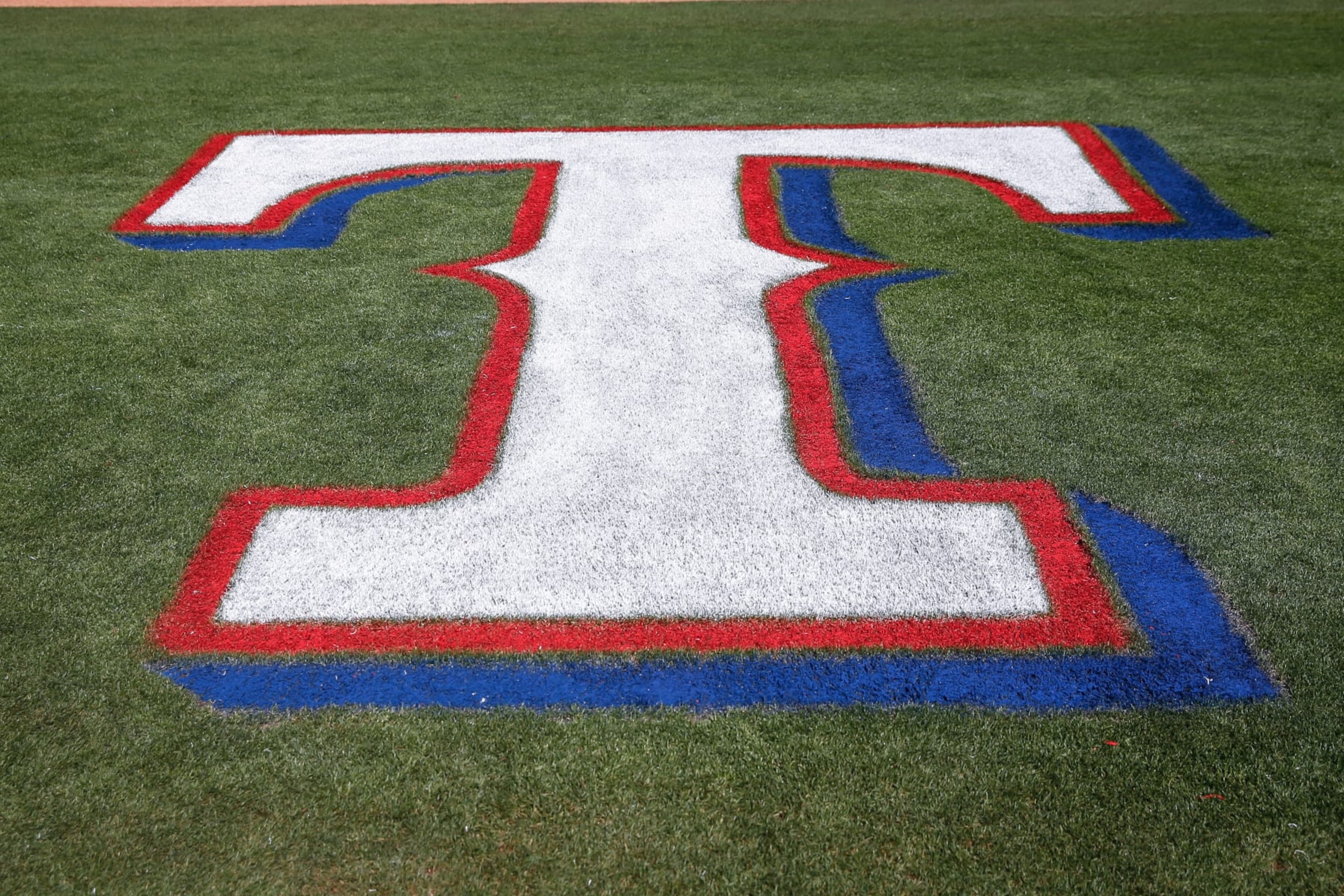 SURPRISE, AZ - MARCH 08: The Texas Rangers logo on the field before the spring training MLB baseball game between the Los Angeles Dodgers and the Texas Rangers on March 8, 2020 at Surprise Stadium in Surprise, Arizona. (Photo by Kevin Abele/Icon Sportswire via Getty Images) SURPRISE, AZ - MARCH 08: The Texas Rangers logo on the field before the spring training MLB baseball game between the Los Angeles Dodgers and the Texas Rangers on March 8, 2020 at Surprise Stadium in Surprise, Arizona. (Photo by Kevin Abele/Icon Sportswire via Getty Images)