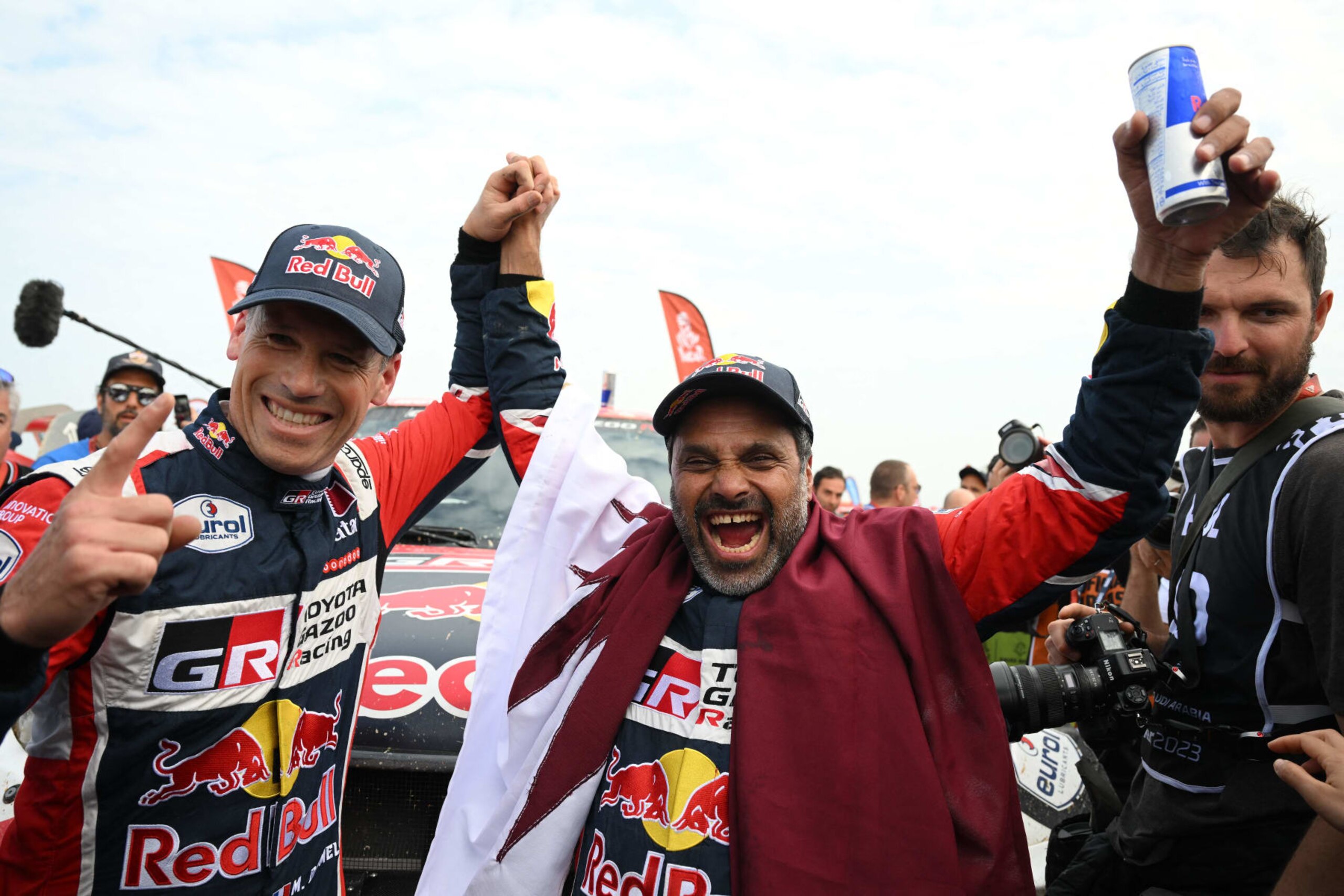 Toyota's driver Nasser Al-Attiyah (R) of Qatar and his co-driver Mathieu Baumel of France celebrate their victory after winning the Dakar Rally 2023, at the end of the last stage between between Al-Hofuf and Dammam, Saudi Arabia, on January 15, 2023. - Qatari driver Nasser Al-Attiyah won his fifth Dakar Rally driver's title and second in a row today after the iconic test of endurance finished in Dammam, Saudi Arabia. (Photo by FRANCK FIFE / AFP) (Photo by FRANCK FIFE/AFP via Getty Images) Toyota's driver Nasser Al-Attiyah (R) of Qatar and his co-driver Mathieu Baumel of France celebrate their victory after winning the Dakar Rally 2023, at the end of the last stage between between Al-Hofuf and Dammam, Saudi Arabia, on January 15, 2023. - Qatari driver Nasser Al-Attiyah won his fifth Dakar Rally driver's title and second in a row today after the iconic test of endurance finished in Dammam, Saudi Arabia. (Photo by FRANCK FIFE / AFP) (Photo by FRANCK FIFE/AFP via Getty Images)
