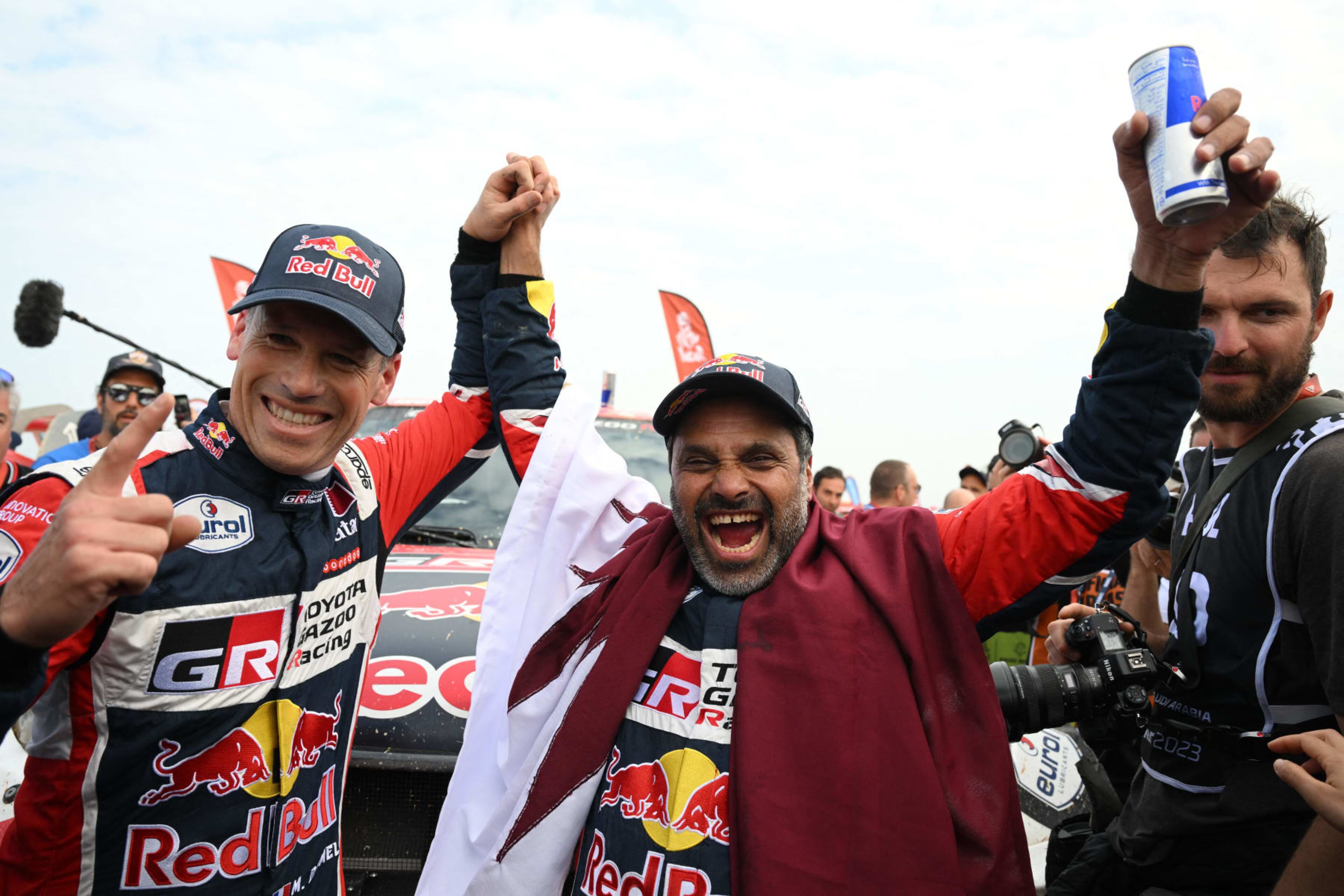 Toyota's driver Nasser Al-Attiyah (R) of Qatar and his co-driver Mathieu Baumel of France celebrate their victory after winning the Dakar Rally 2023, at the end of the last stage between between Al-Hofuf and Dammam, Saudi Arabia, on January 15, 2023. - Qatari driver Nasser Al-Attiyah won his fifth Dakar Rally driver's title and second in a row today after the iconic test of endurance finished in Dammam, Saudi Arabia. (Photo by FRANCK FIFE / AFP) (Photo by FRANCK FIFE/AFP via Getty Images)
