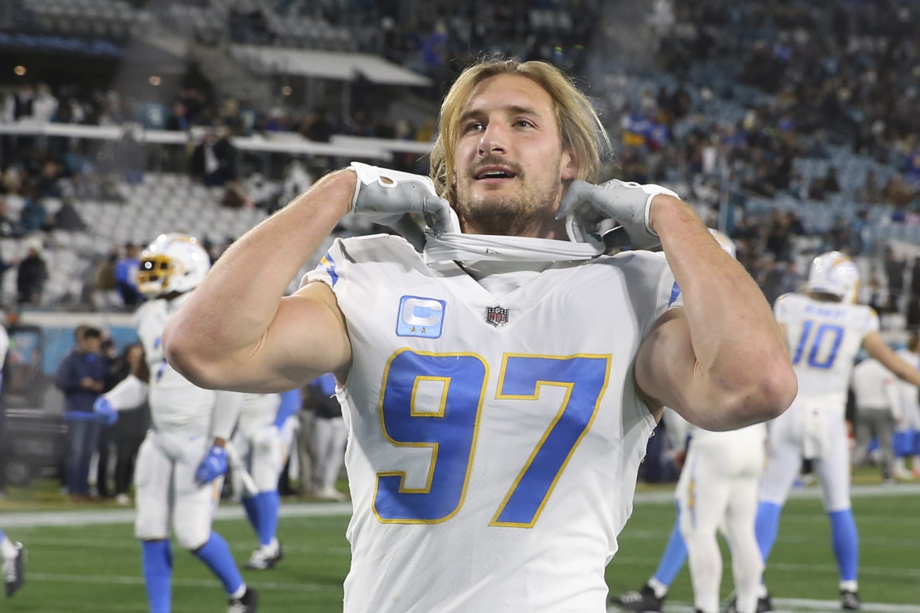 Los Angeles Chargers linebacker Joey Bosa (97) talks with a fan in the stands before an NFL wild-card football game against the Jacksonville Jaguars, Saturday, Jan. 14, 2023, in Jacksonville, Fla. (AP Photo/Gary McCullough)