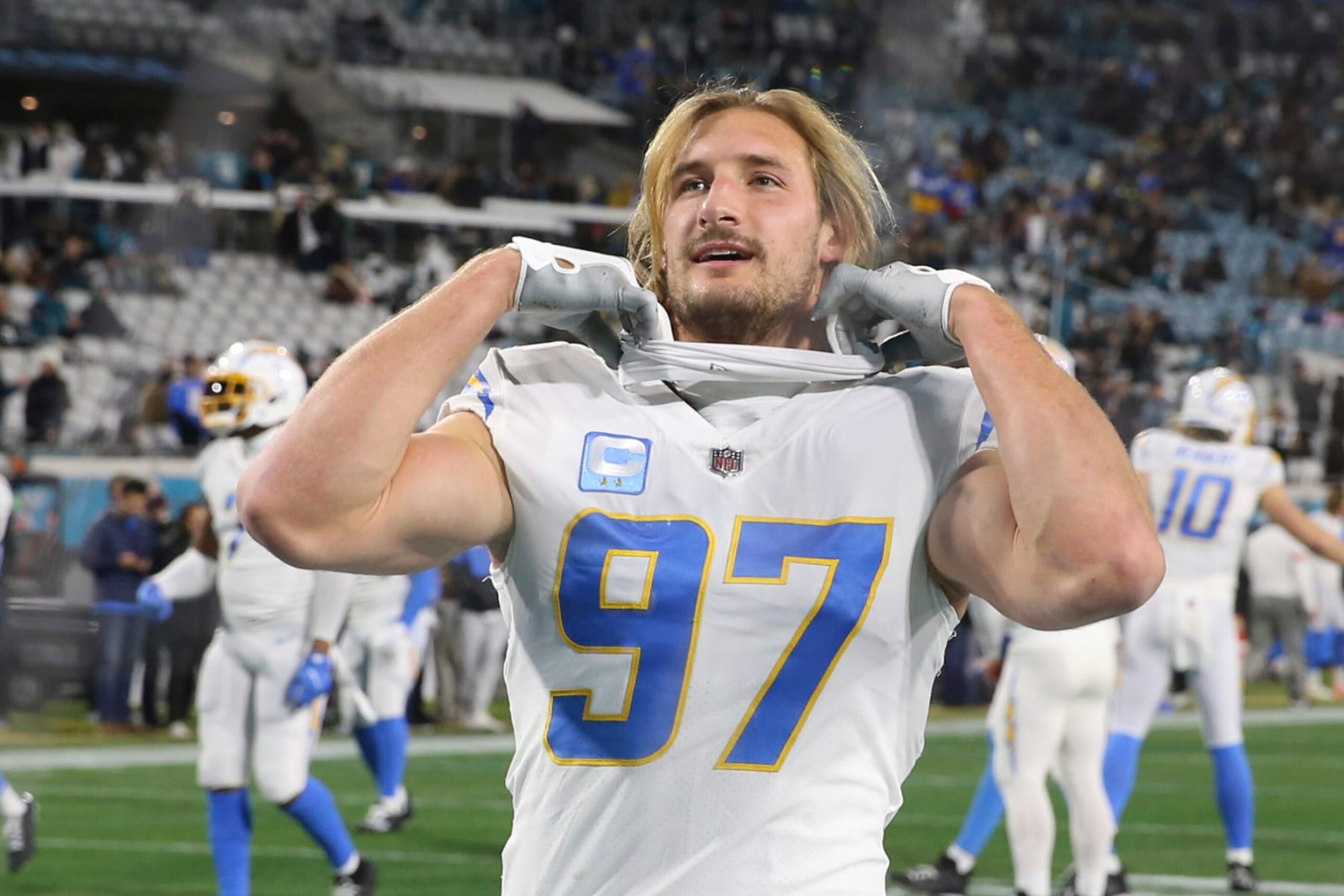 Los Angeles Chargers linebacker Joey Bosa (97) talks with a fan in the stands before an NFL wild-card football game against the Jacksonville Jaguars, Saturday, Jan. 14, 2023, in Jacksonville, Fla. (AP Photo/Gary McCullough)