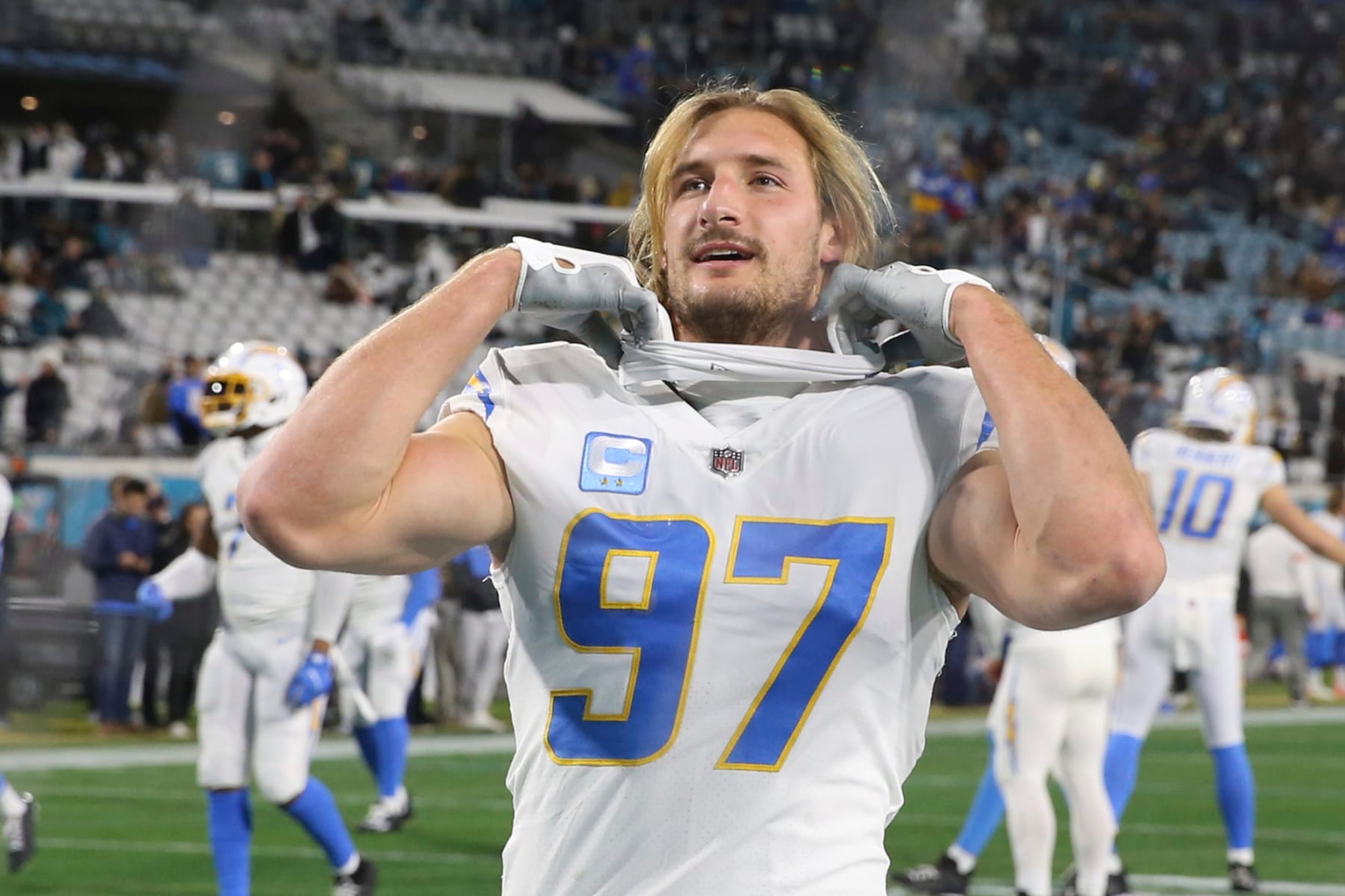 Los Angeles Chargers linebacker Joey Bosa (97) talks with a fan in the stands before an NFL wild-card football game against the Jacksonville Jaguars, Saturday, Jan. 14, 2023, in Jacksonville, Fla. (AP Photo/Gary McCullough)