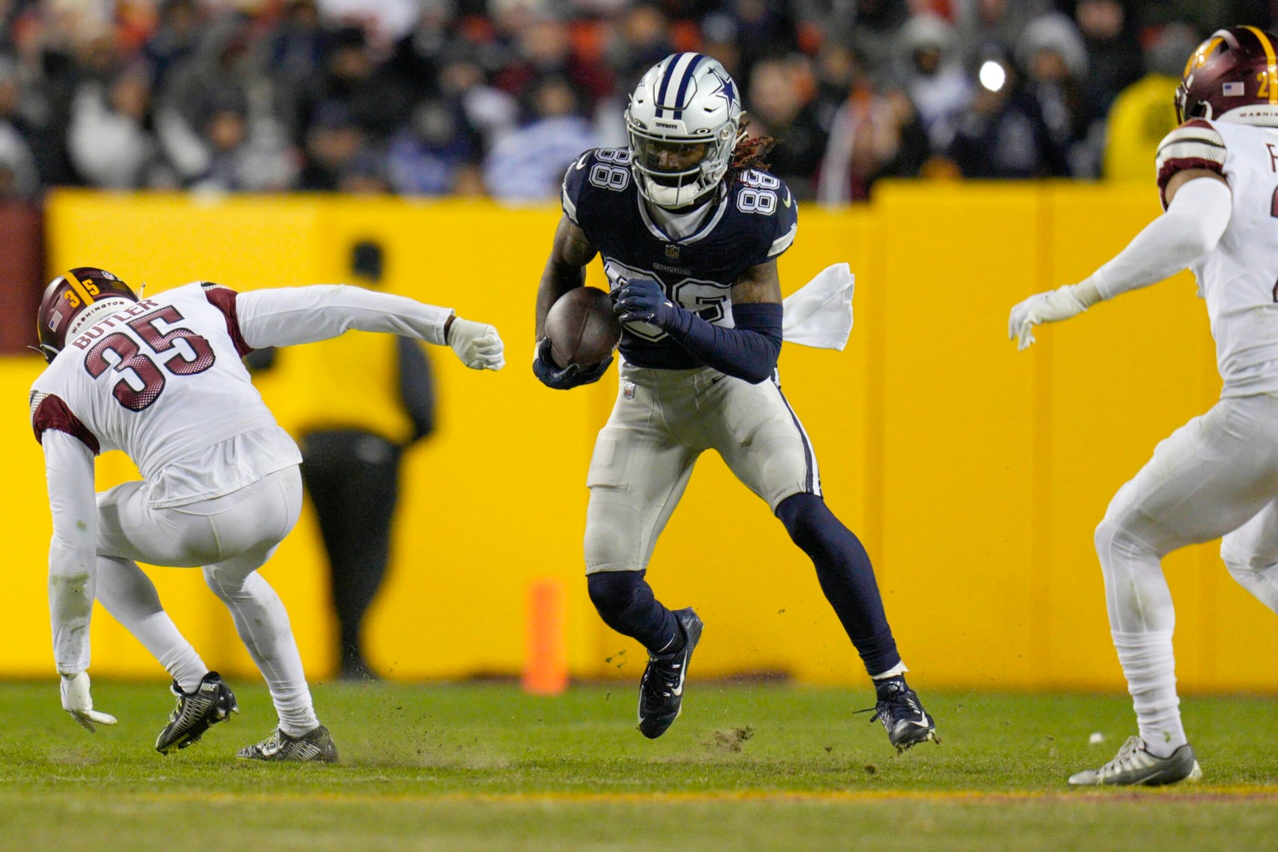 LANDOVER, MARYLAND - JANUARY 08: CeeDee Lamb #88 of the Dallas Cowboys runs with the ball as Percy Butler #35 of the Washington Commanders defends during the second half at FedExField on January 08, 2023 in Landover, Maryland. (Photo by Jess Rapfogel/Getty Images)
