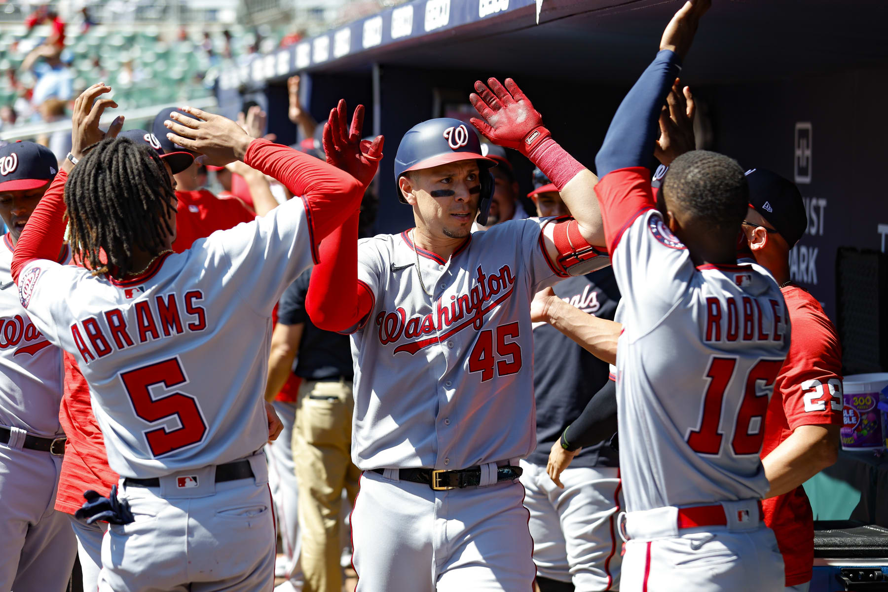 ATLANTA, GA - SEPTEMBER 21: Joey Meneses #45 reacts with CJ Abrams #5 and Victor Robles #16 of the Washington Nationals after a two run home run during the seventh inning against the Atlanta Braves at Truist Park on September 21, 2022 in Atlanta, Georgia. (Photo by Todd Kirkland/Getty Images)