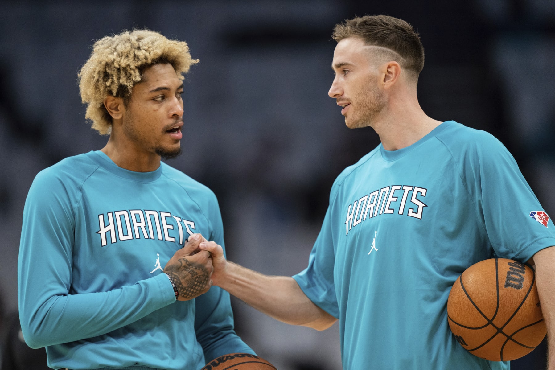 Charlotte Hornets guard Kelly Oubre Jr., left, talks with forward Gordon Hayward, right, during warm ups before an NBA basketball game against the Indiana Pacers in Charlotte, N.C., Wednesday, Oct. 20, 2021. (AP Photo/Jacob Kupferman)