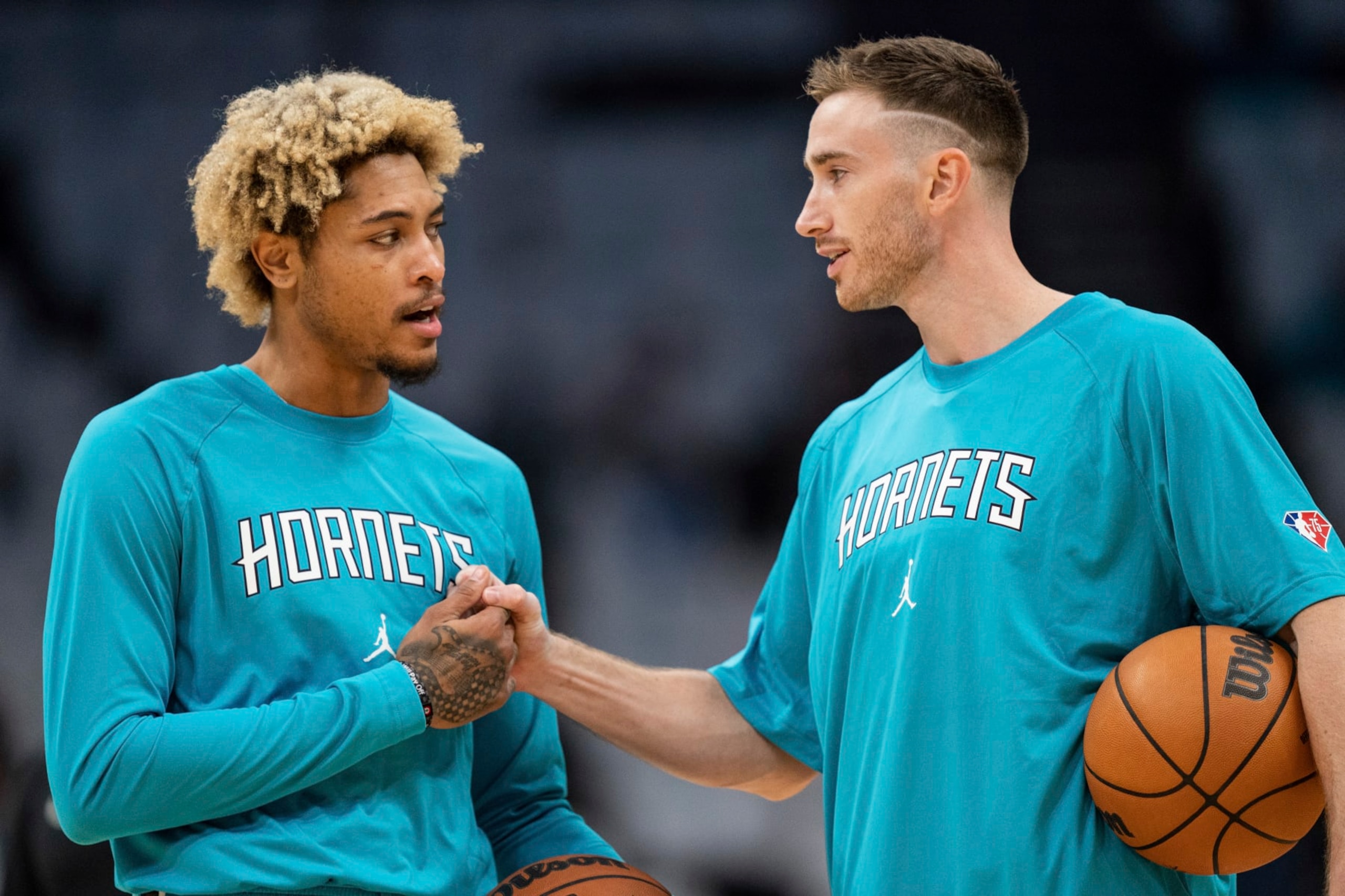 Charlotte Hornets guard Kelly Oubre Jr., left, talks with forward Gordon Hayward, right, during warm ups before an NBA basketball game against the Indiana Pacers in Charlotte, N.C., Wednesday, Oct. 20, 2021. (AP Photo/Jacob Kupferman)