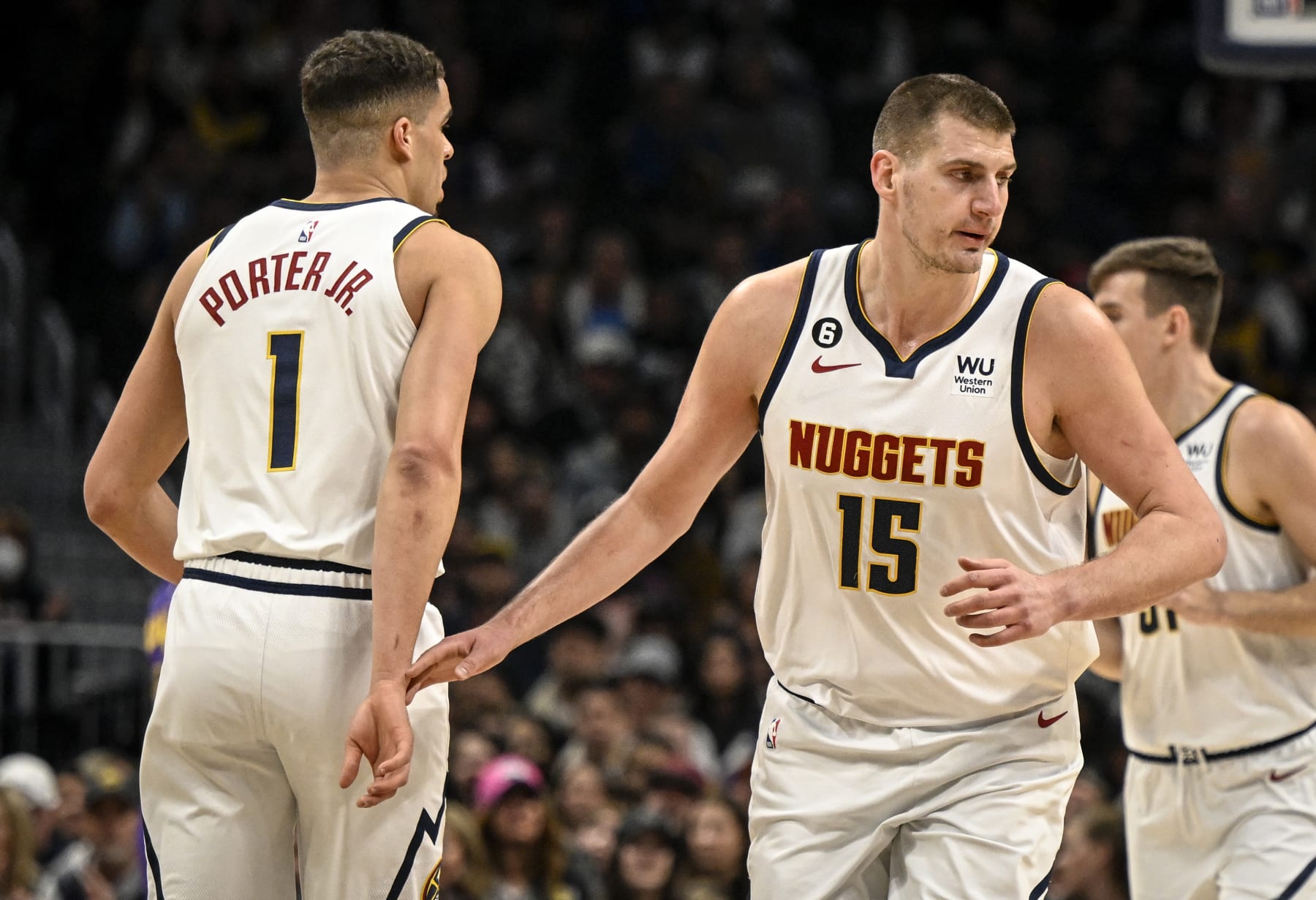 DENVER, CO - JANUARY 9: Nikola Jokic (15) of the Denver Nuggets gingerly grazes the wrist of teammate Michael Porter Jr. (1) after Jokic earned an assist on a Porter Jr. three pointer during the first quarter at Ball Arena in Denver on Monday, January 9, 2023. (Photo by AAron Ontiveroz/MediaNews Group/The Denver Post via Getty Images)