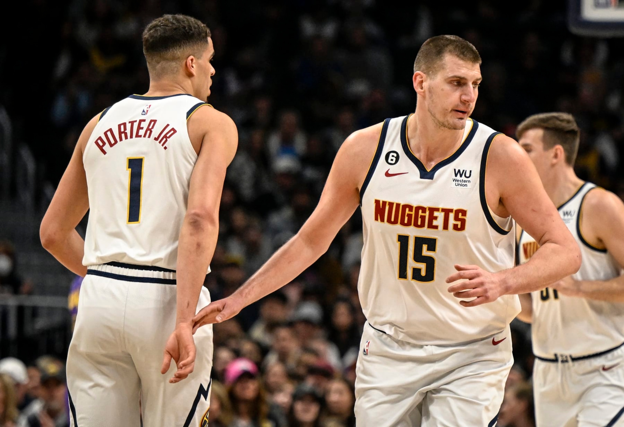 DENVER, CO - JANUARY 9: Nikola Jokic (15) of the Denver Nuggets gingerly grazes the wrist of teammate Michael Porter Jr. (1) after Jokic earned an assist on a Porter Jr. three pointer during the first quarter at Ball Arena in Denver on Monday, January 9, 2023. (Photo by AAron Ontiveroz/MediaNews Group/The Denver Post via Getty Images)