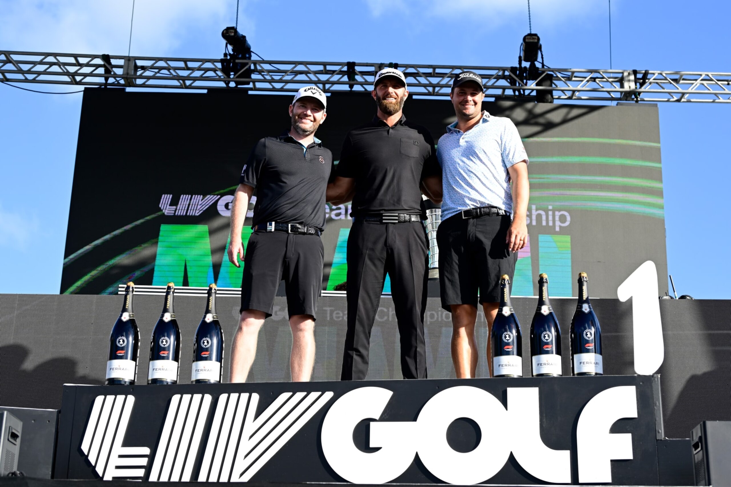 DORAL, FLORIDA - OCTOBER 30: Individual champion team Captain Dustin Johnson (C) of 4 Aces GC, second place individual award winner Branden Grace (L) of Stinger GC, and third place individual award winner Peter Uihlein (R) of Smash GC pose on stage after the team championship stroke-play round of the LIV Golf Invitational - Miami at Trump National Doral Miami on October 30, 2022 in Doral, Florida. (Photo by Charles Laberge/LIV Golf via Getty Images)