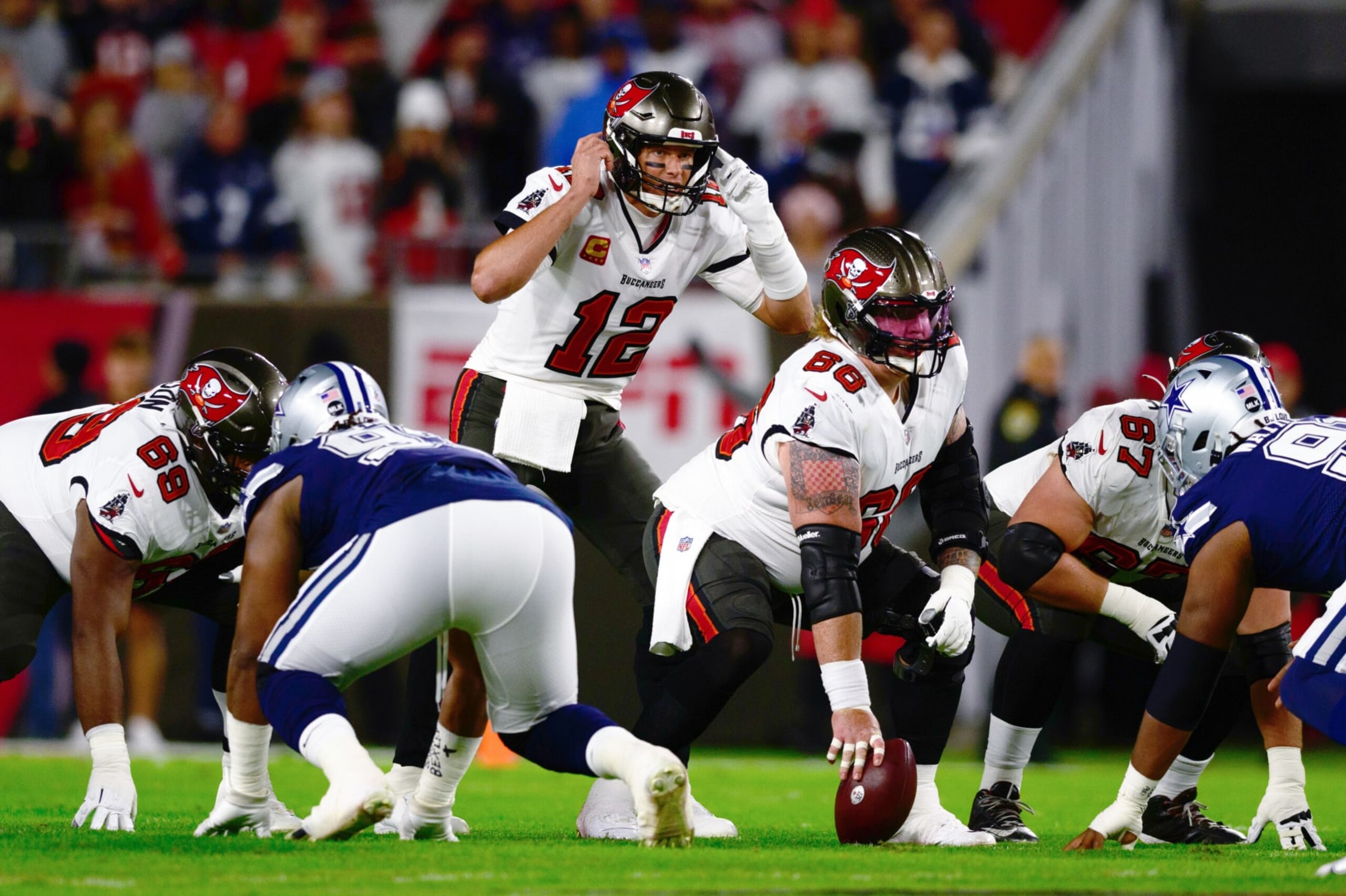 TAMPA, FLORIDA - JANUARY 16: Tom Brady #12 of the Tampa Bay Buccaneers looks on at the line of scrimmage against the Dallas Cowboys during the first half in the NFC Wild Card playoff game at Raymond James Stadium on January 16, 2023 in Tampa, Florida. (Photo by Julio Aguilar/Getty Images) TAMPA, FLORIDA - JANUARY 16: Tom Brady #12 of the Tampa Bay Buccaneers looks on at the line of scrimmage against the Dallas Cowboys during the first half in the NFC Wild Card playoff game at Raymond James Stadium on January 16, 2023 in Tampa, Florida. (Photo by Julio Aguilar/Getty Images)