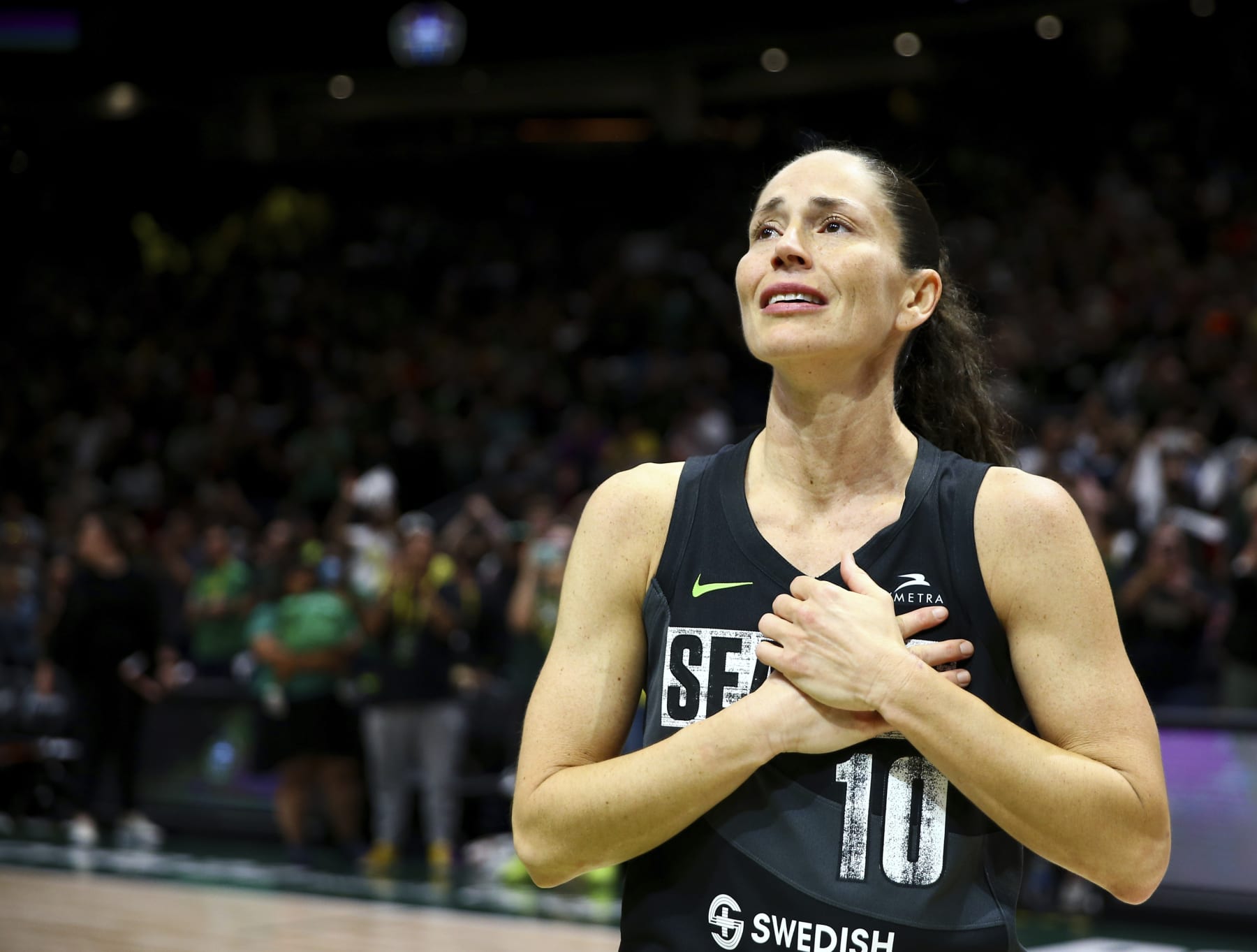 Seattle Storm guard Sue Bird puts her hands over her heart as she acknowledges fans chanting her name after her team was eliminated from the playoffs by the Las Vegas Aces in Game 4 of a WNBA basketball playoff semifinal, making it her last career game, Tuesday, Sept. 6, 2022, in Seattle. The Aces beat the Storm 97-92 to advance to the WNBA Finals. (AP Photo/Lindsey Wasson)