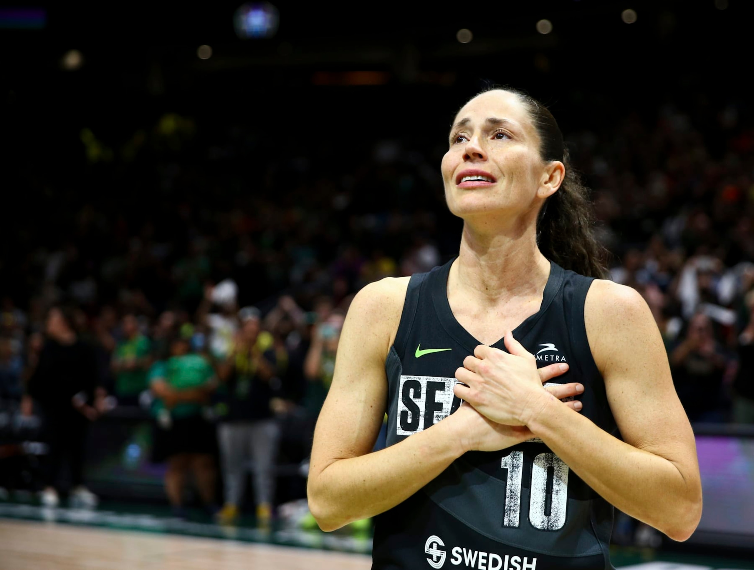 Seattle Storm guard Sue Bird puts her hands over her heart as she acknowledges fans chanting her name after her team was eliminated from the playoffs by the Las Vegas Aces in Game 4 of a WNBA basketball playoff semifinal, making it her last career game, Tuesday, Sept. 6, 2022, in Seattle. The Aces beat the Storm 97-92 to advance to the WNBA Finals. (AP Photo/Lindsey Wasson)