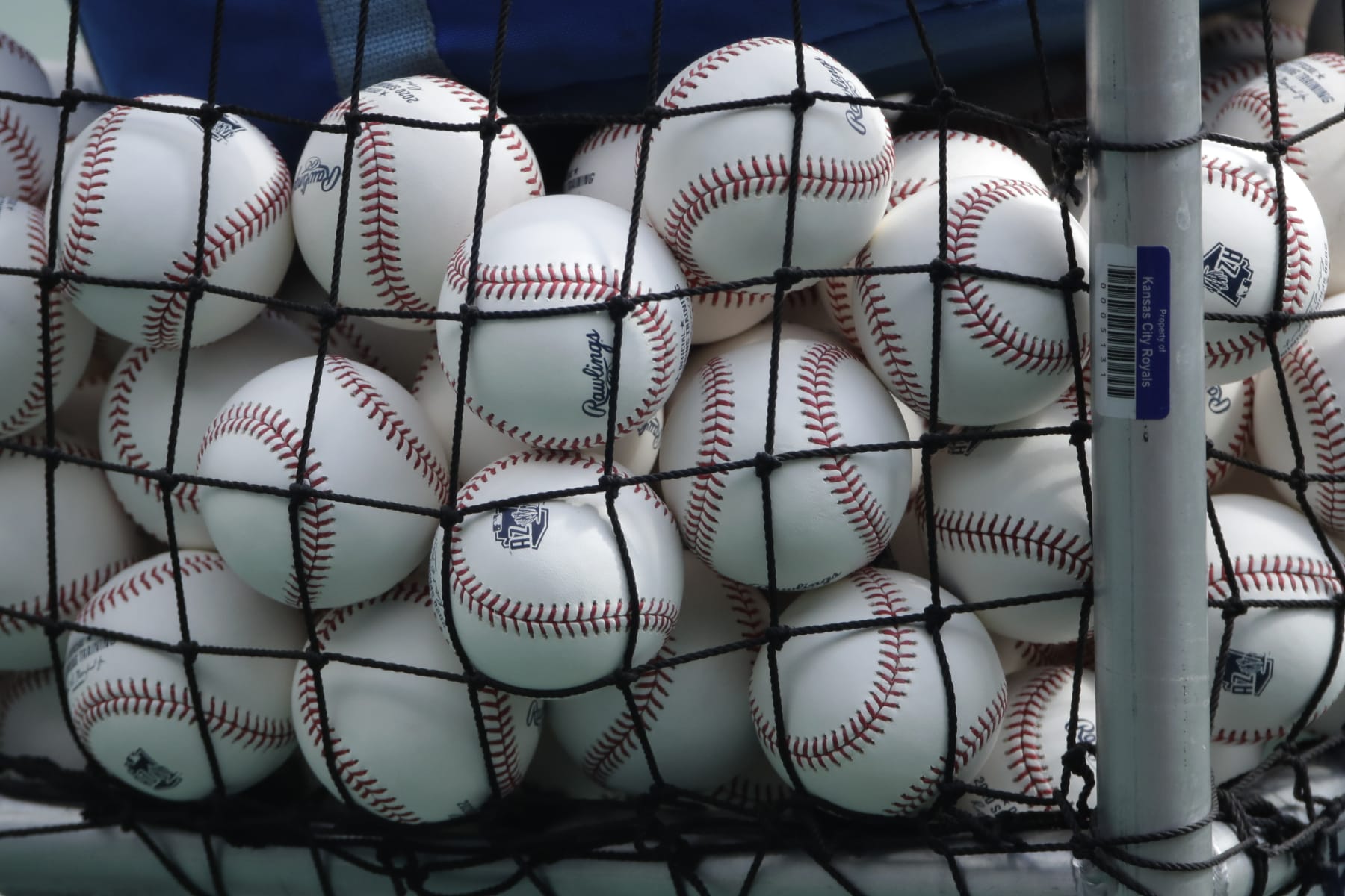 FILE - In this July 3, 2020, file photo, balls marked with Cactus League spring training logos are in a basket during Kansas City Royals baseball practice at Kauffman Stadium in Kansas City, Mo. Major League Baseball has slightly deadened its baseballs amid a years-long surge in home runs.MLB anticipates the changes will be subtle, and a memo to teams last week cites an independent lab that found the new balls will fly 1 to 2 feet shorter on balls hit over 375 feet. (AP Photo/Charlie Riedel, File)