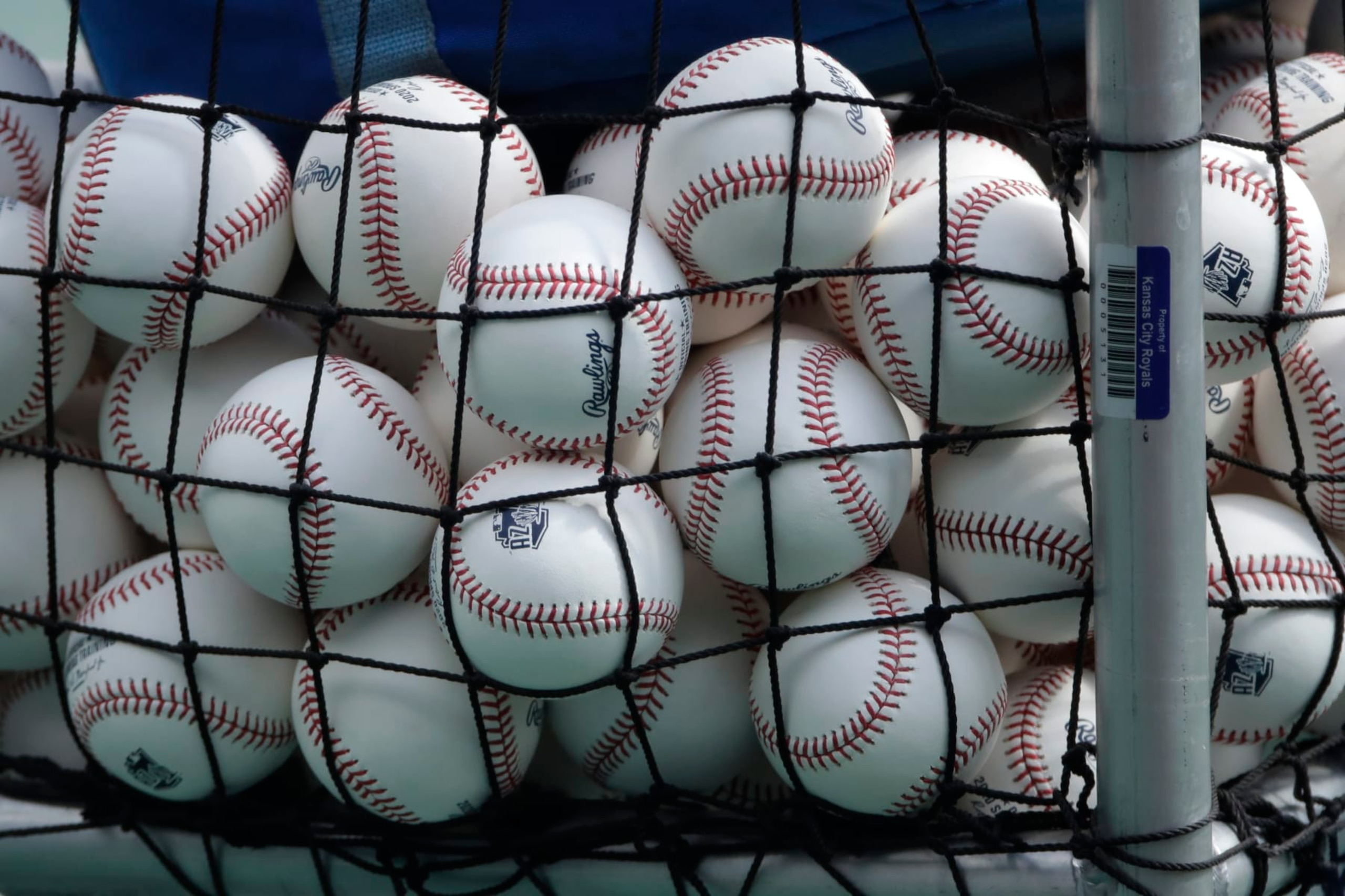 FILE - In this July 3, 2020, file photo, balls marked with Cactus League spring training logos are in a basket during Kansas City Royals baseball practice at Kauffman Stadium in Kansas City, Mo. Major League Baseball has slightly deadened its baseballs amid a years-long surge in home runs.MLB anticipates the changes will be subtle, and a memo to teams last week cites an independent lab that found the new balls will fly 1 to 2 feet shorter on balls hit over 375 feet. (AP Photo/Charlie Riedel, File)