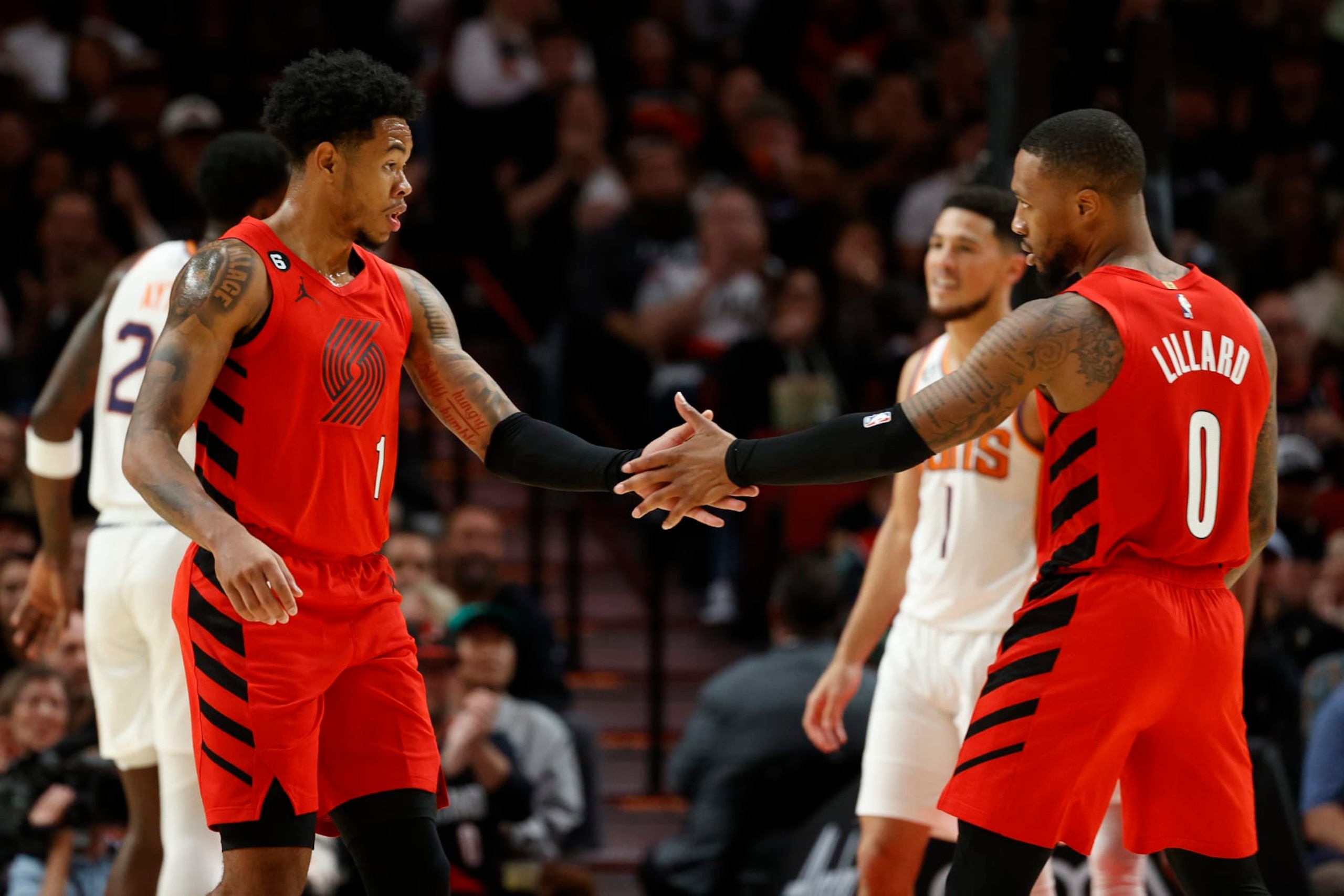 PORTLAND, OREGON - OCTOBER 21: Anfernee Simons #1 and Damian Lillard #0 of the Portland Trail Blazers high five against the Phoenix Suns during the second quarter at Moda Center on October 21, 2022 in Portland, Oregon. NOTE TO USER: User expressly acknowledges and agrees that, by downloading and or using this photograph, User is consenting to the terms and conditions of the Getty Images License Agreement. (Photo by Steph Chambers/Getty Images)