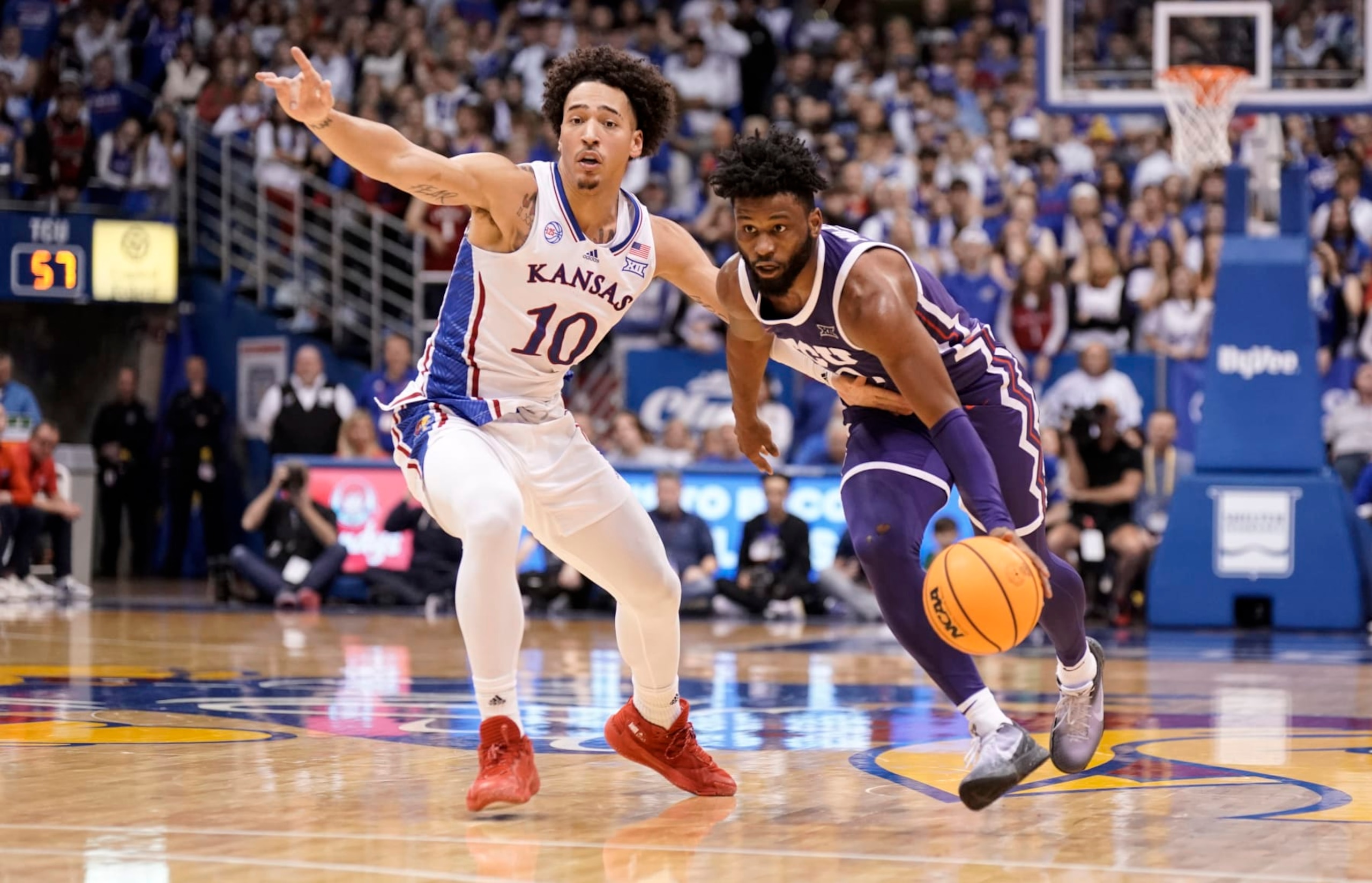 TCU guard Mike Miles Jr. (1) drives past Kansas forward Jalen Wilson (10) during the second half of an NCAA college basketball game on Saturday, Jan. 21, 2023, at Allen Fieldhouse in Lawrence, Kan. TCU defeated Kansas, 83-60. (AP Photo/Nick Krug)