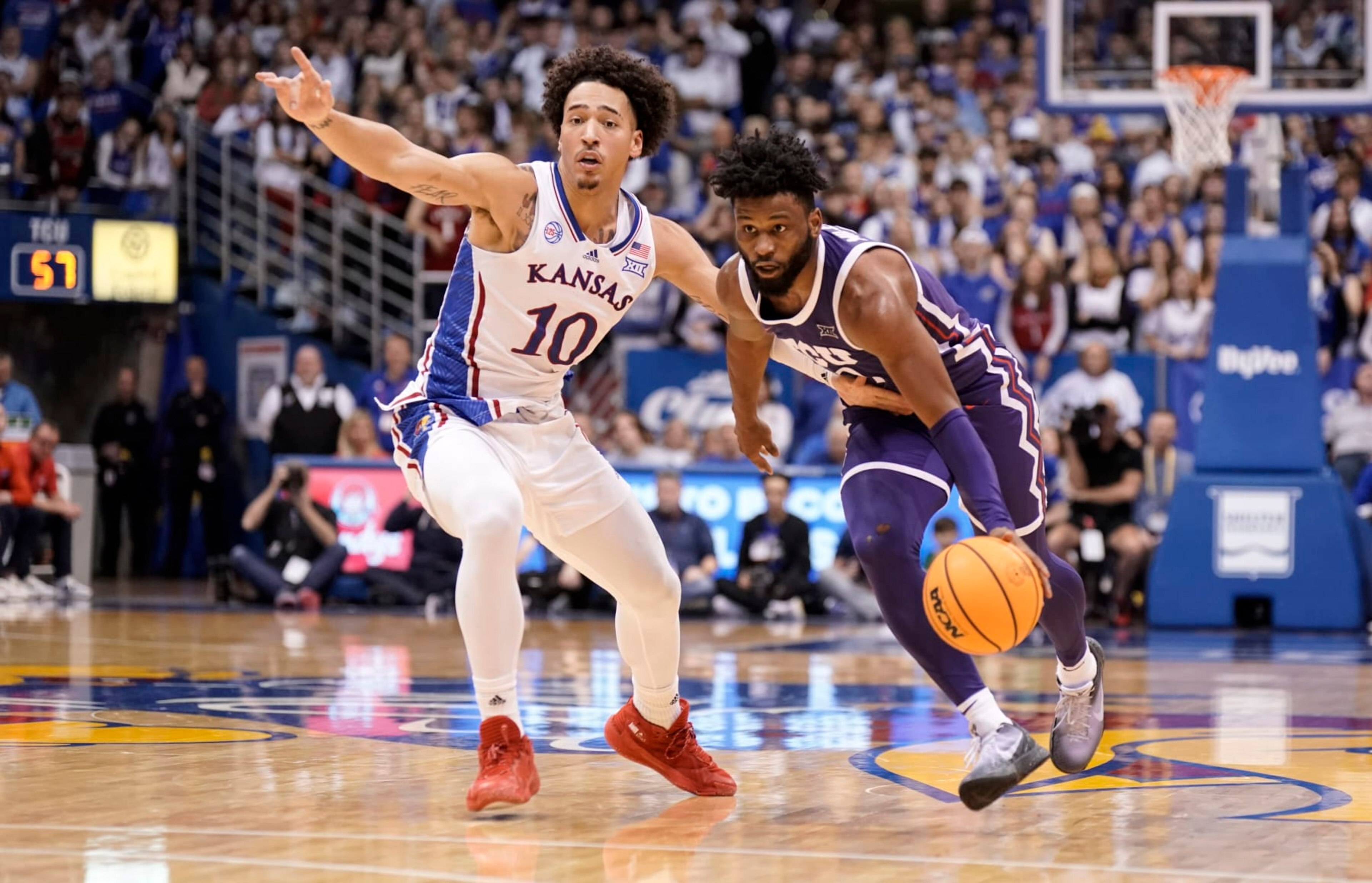 TCU guard Mike Miles Jr. (1) drives past Kansas forward Jalen Wilson (10) during the second half of an NCAA college basketball game on Saturday, Jan. 21, 2023, at Allen Fieldhouse in Lawrence, Kan. TCU defeated Kansas, 83-60. (AP Photo/Nick Krug)