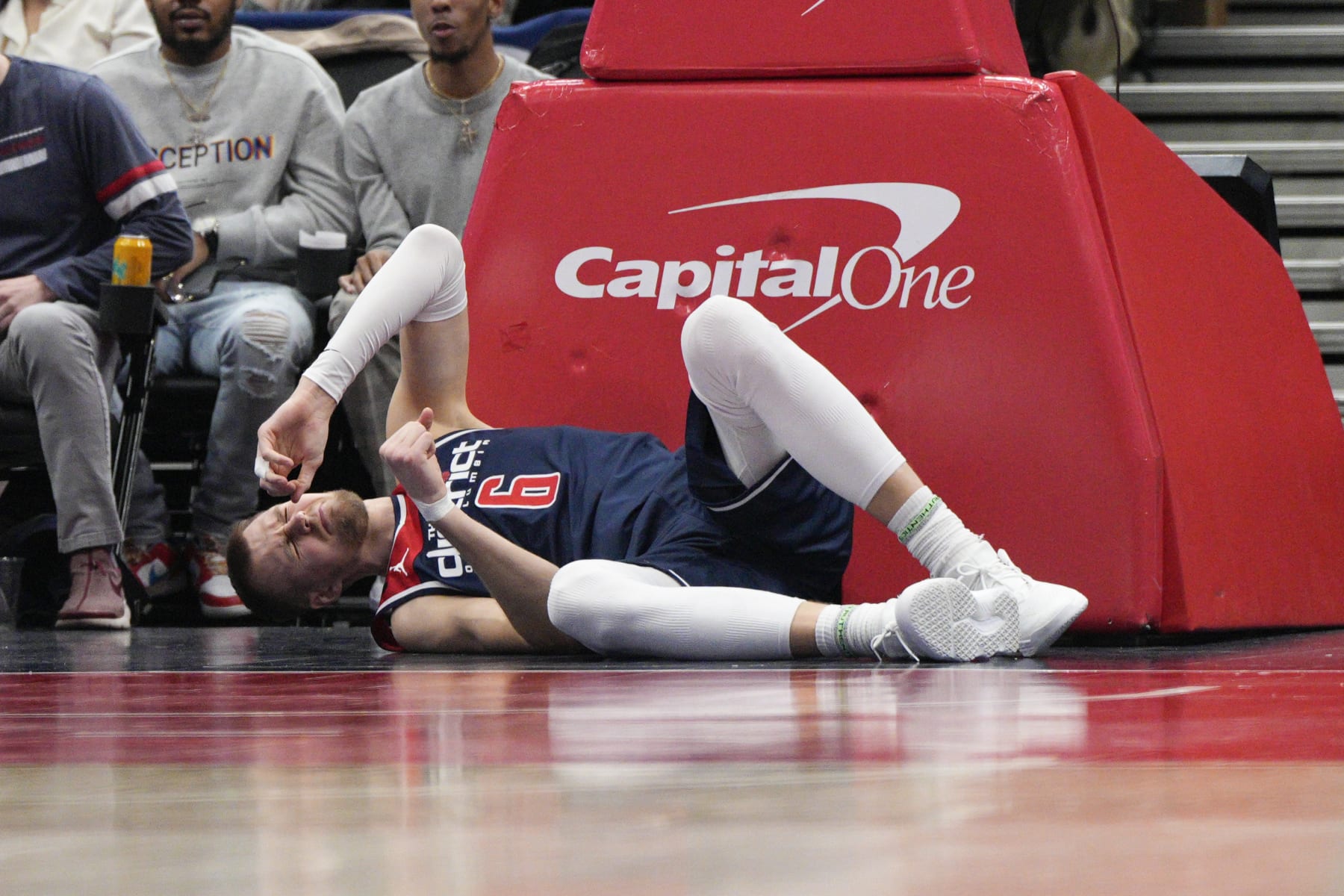 Washington Wizards center Kristaps Porzingis (6) lies on the floor after being injured during the second half of an NBA basketball game against the Orlando Magic, Saturday, Jan. 21, 2023, in Washington. Porzingis left the game and did not return. (AP Photo/Jess Rapfogel)