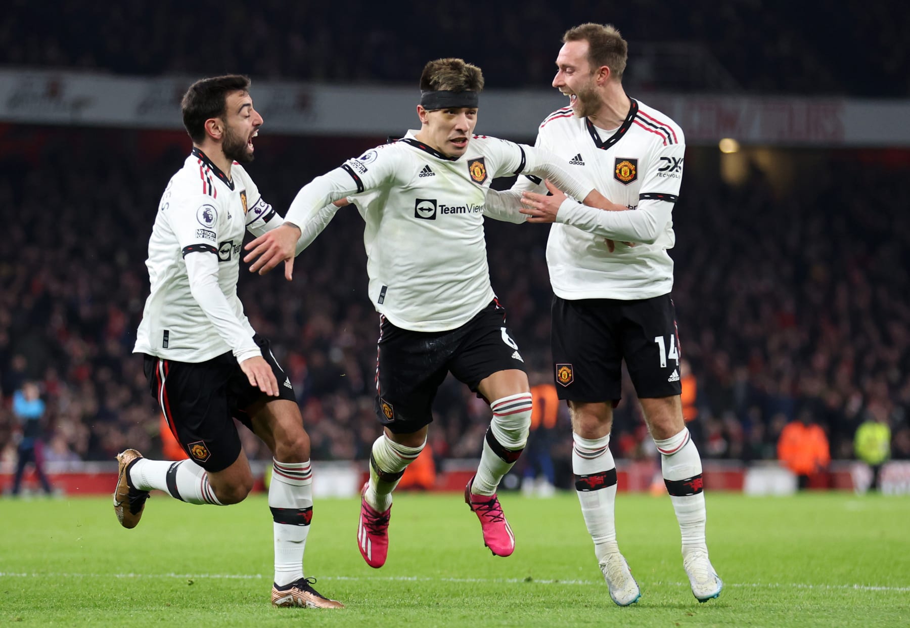 LONDON, ENGLAND - JANUARY 22: Lisandro Martinez celebrates with Bruno Fernandes and Christian Eriksen of Manchester United after scoring the team's second goal during the Premier League match between Arsenal FC and Manchester United at Emirates Stadium on January 22, 2023 in London, England. (Photo by Catherine Ivill/Getty Images)