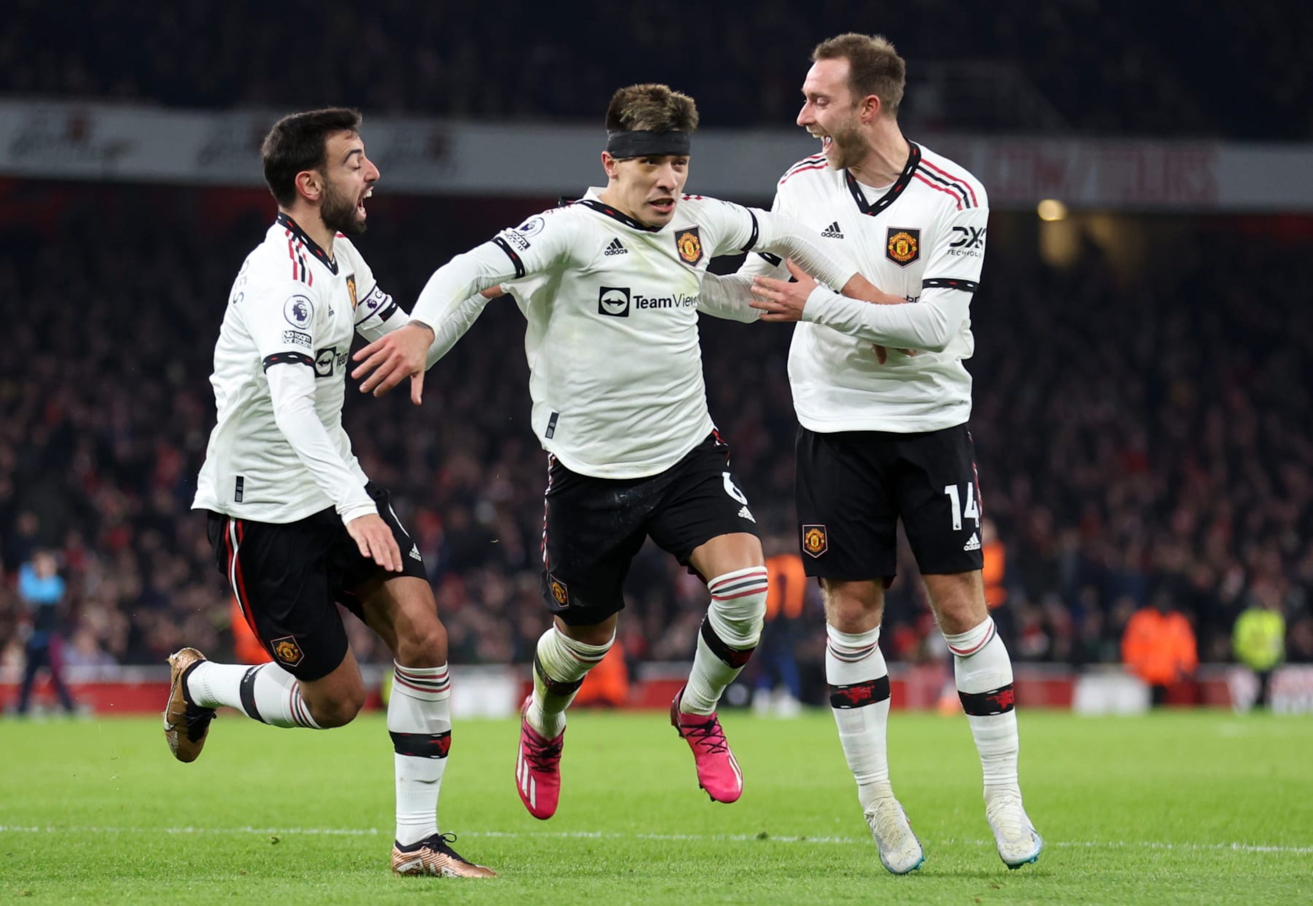 LONDON, ENGLAND - JANUARY 22: Lisandro Martinez celebrates with Bruno Fernandes and Christian Eriksen of Manchester United after scoring the team's second goal during the Premier League match between Arsenal FC and Manchester United at Emirates Stadium on January 22, 2023 in London, England. (Photo by Catherine Ivill/Getty Images) LONDON, ENGLAND - JANUARY 22: Lisandro Martinez celebrates with Bruno Fernandes and Christian Eriksen of Manchester United after scoring the team's second goal during the Premier League match between Arsenal FC and Manchester United at Emirates Stadium on January 22, 2023 in London, England. (Photo by Catherine Ivill/Getty Images)