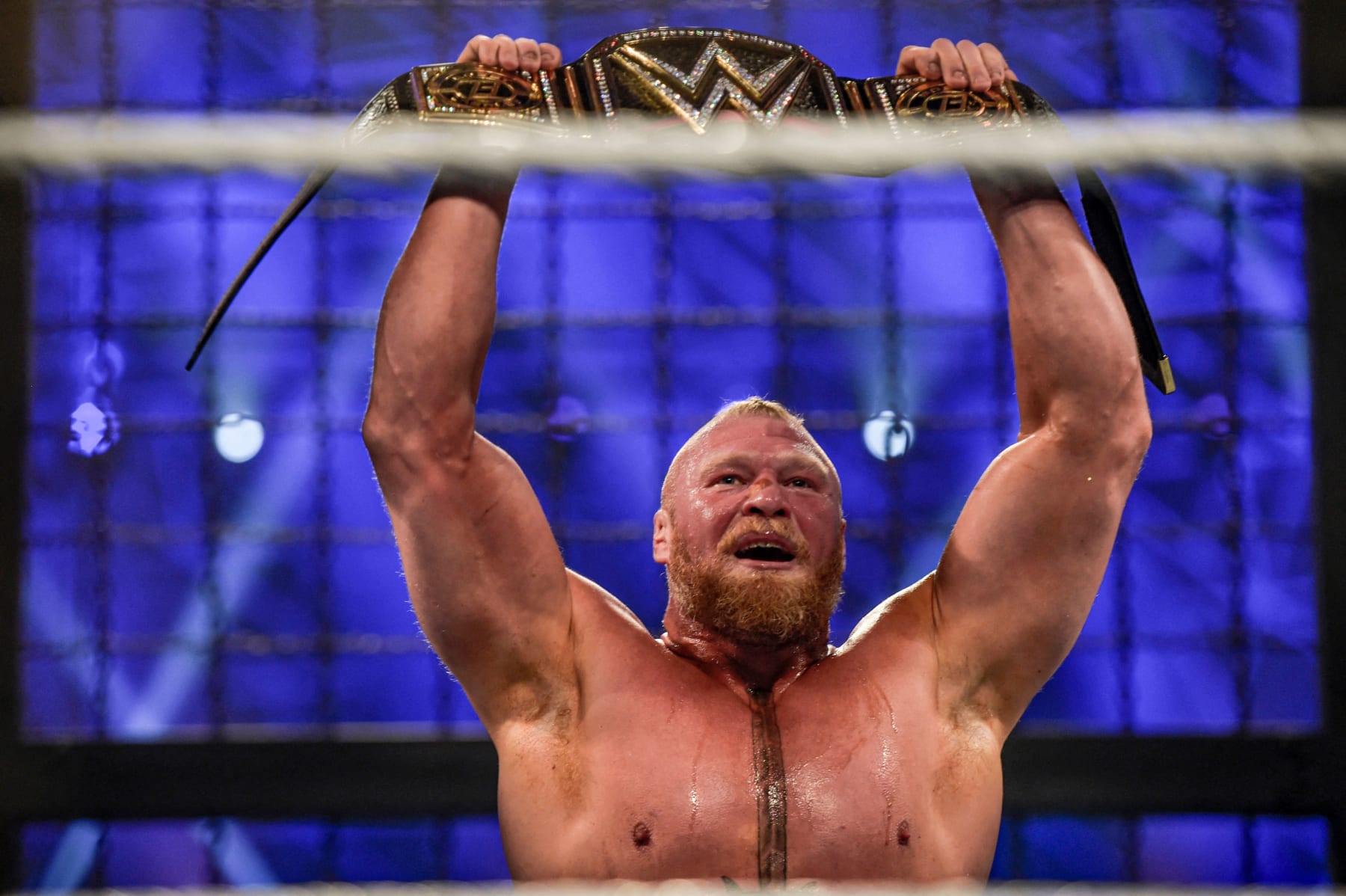 Brock Lesnar holds up the championship belt after winning the 2022 World Wrestling Entertainment (WWE) Elimination Chamber at the Jeddah Super Dome in Saudi Arabia's Red Sea coastal city of Jeddah on February 19, 2022. (Photo by Amer HILABI / AFP) (Photo by AMER HILABI/AFP via Getty Images)