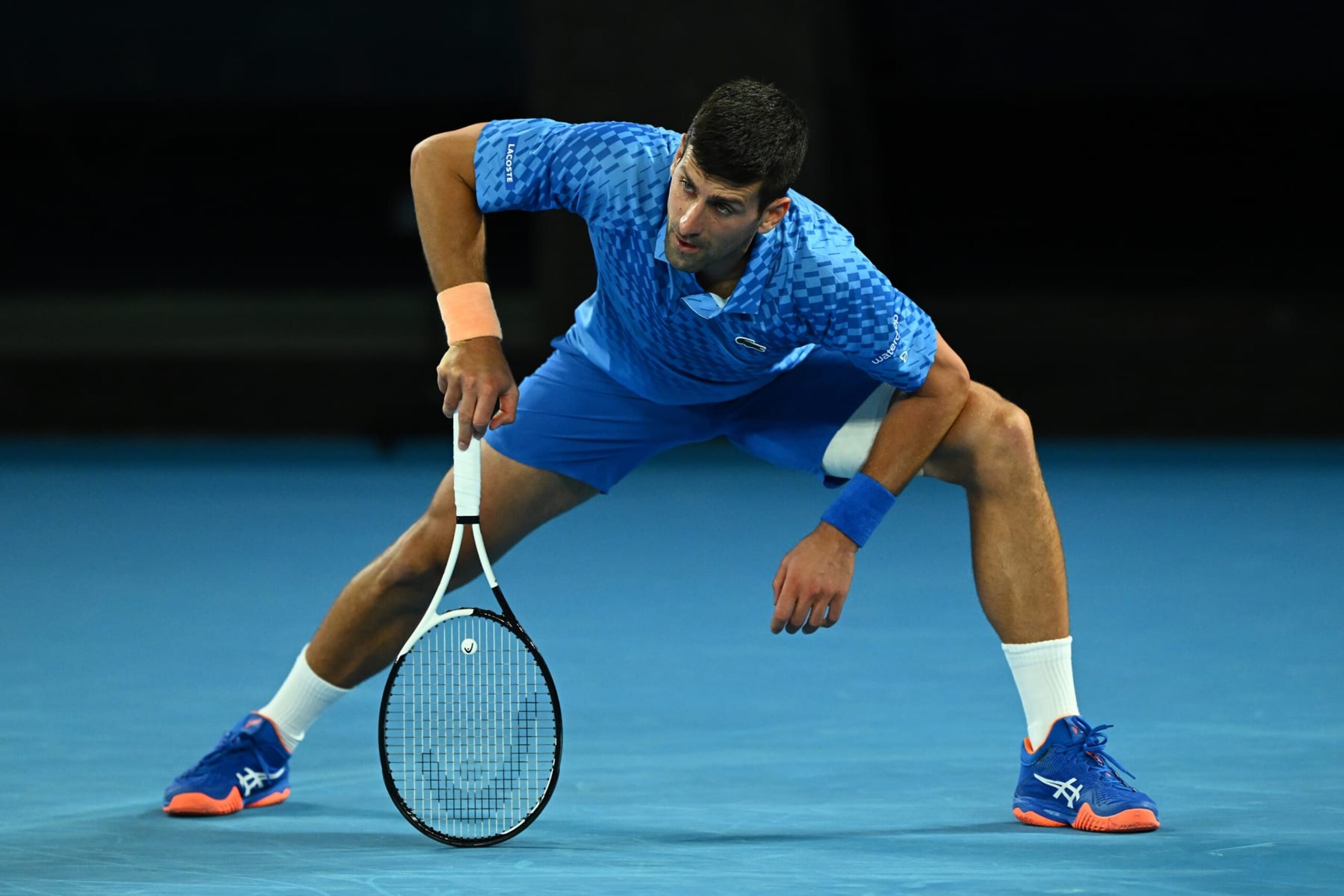 MELBOURNE, AUSTRALIA - JANUARY 21: Novak Djokovic of Serbia stretches during the third round singles match against Grigor Dimitrov of Bulgaria during day six of the 2023 Australian Open at Melbourne Park on January 21, 2023 in Melbourne, Australia. (Photo by Quinn Rooney/Getty Images)
