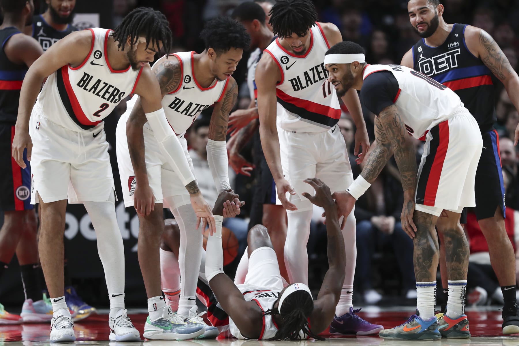 PORTLAND, OREGON - JANUARY 02: Trendon Watford #2, Anfernee Simons #1, Josh Hart #11, and Gary Payton II #00 of the Portland Trail Blazers help teammate Jerami Grant #9 up during a game against the Detroit Pistons at Moda Center on January 02, 2023 in Portland, Oregon. NOTE TO USER: User expressly acknowledges and agrees that, by downloading and or using this photograph, User is consenting to the terms and conditions of the Getty Images License Agreement.  (Photo by Amanda Loman/Getty Images)