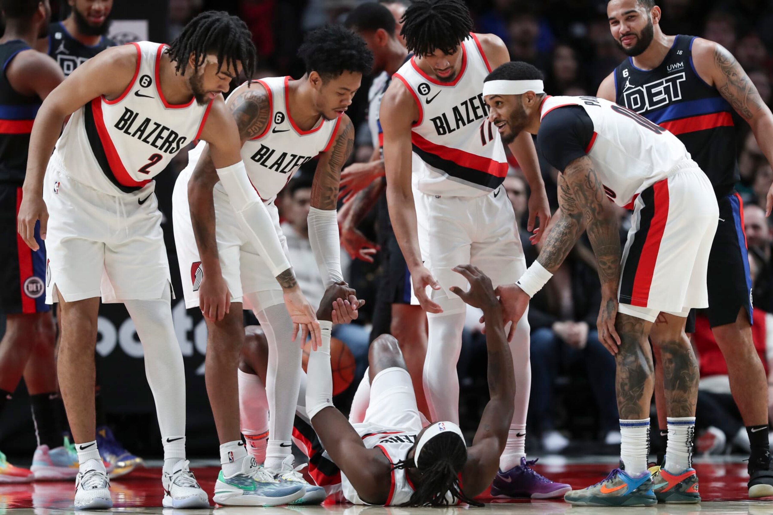 PORTLAND, OREGON - JANUARY 02: Trendon Watford #2, Anfernee Simons #1, Josh Hart #11, and Gary Payton II #00 of the Portland Trail Blazers help teammate Jerami Grant #9 up during a game against the Detroit Pistons at Moda Center on January 02, 2023 in Portland, Oregon. NOTE TO USER: User expressly acknowledges and agrees that, by downloading and or using this photograph, User is consenting to the terms and conditions of the Getty Images License Agreement.  (Photo by Amanda Loman/Getty Images)