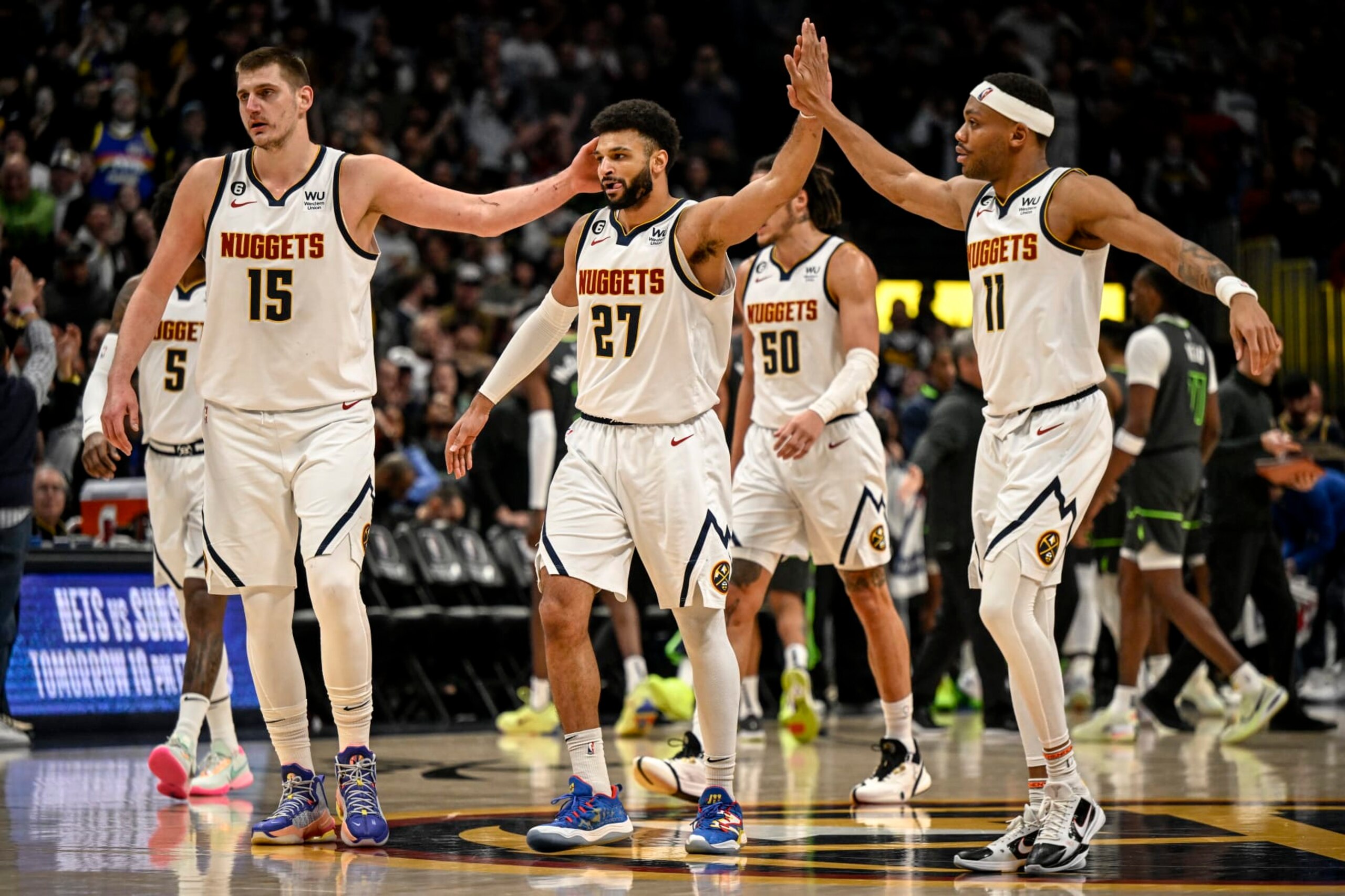 DENVER, CO - JANUARY 18: Nikola Jokic (15) and Bruce Brown (11) reacts to the clutch play of Jamal Murray (27) of the Denver Nuggets down the stretch against the Minnesota Timberwolves during the fourth quarter of the Nuggets 122-118 win at Ball Arena in Denver on Wednesday, January 18, 2023. (Photo by AAron Ontiveroz/The Denver Post)