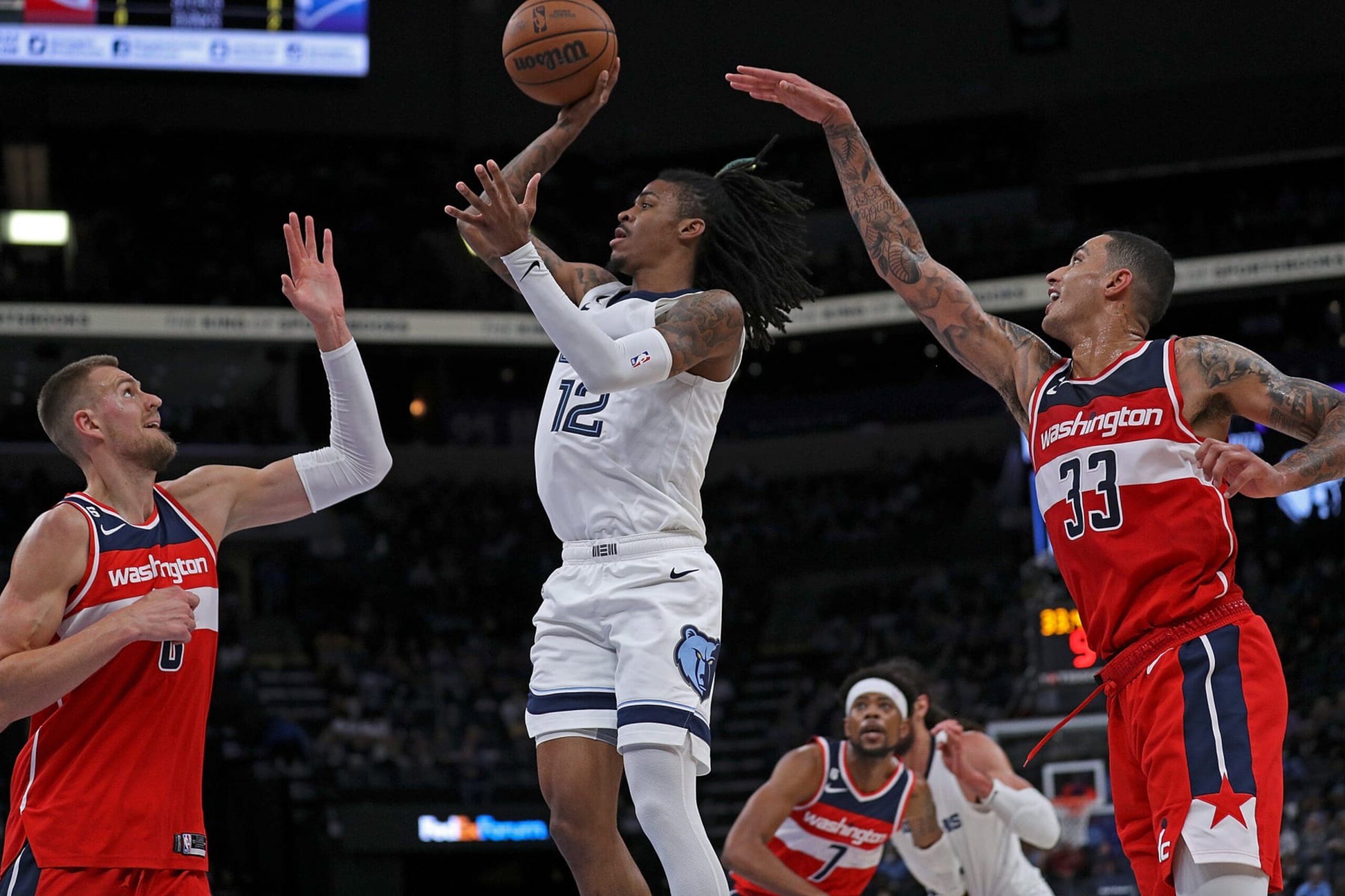 MEMPHIS, TENNESSEE - NOVEMBER 06: Ja Morant #12 of the Memphis Grizzlies takes a shot against Kyle Kuzma #33 and Kristaps Porzingis #6 of the Washington Wizards during the first half at FedExForum on November 06, 2022 in Memphis, Tennessee. NOTE TO USER: User expressly acknowledges and agrees that, by downloading and or using this photograph, User is consenting to the terms and conditions of the Getty Images License Agreement. (Photo by Justin Ford/Getty Images)