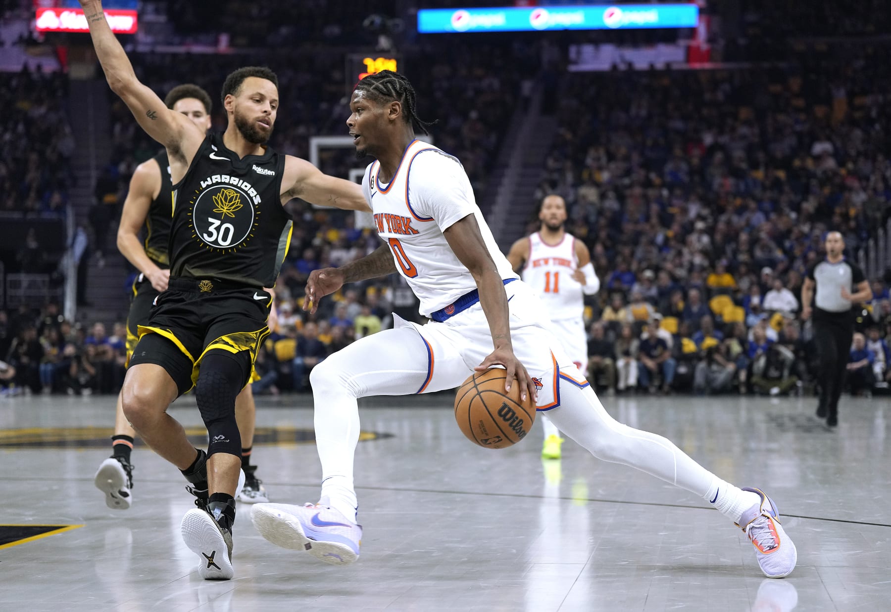 SAN FRANCISCO, CALIFORNIA - NOVEMBER 18: Cam Reddish #0 of the New York Knicks drives to the basket on Stephen Curry #30 of the Golden State Warriors during the first quarter of an NBA basketball game at Chase Center on November 18, 2022 in San Francisco, California. NOTE TO USER: User expressly acknowledges and agrees that, by downloading and or using this photograph, User is consenting to the terms and conditions of the Getty Images License Agreement. (Photo by Thearon W. Henderson/Getty Images)