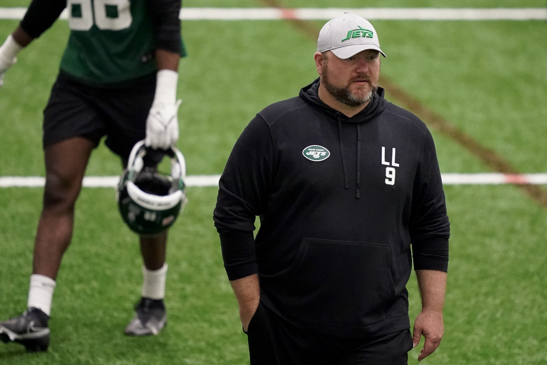 New York Jets' general manager Joe Douglas walks the field has his players practice during the NFL football team's training camp, Friday, May 6, 2022, in Florham Park, N.J. (AP Photo/John Minchillo)