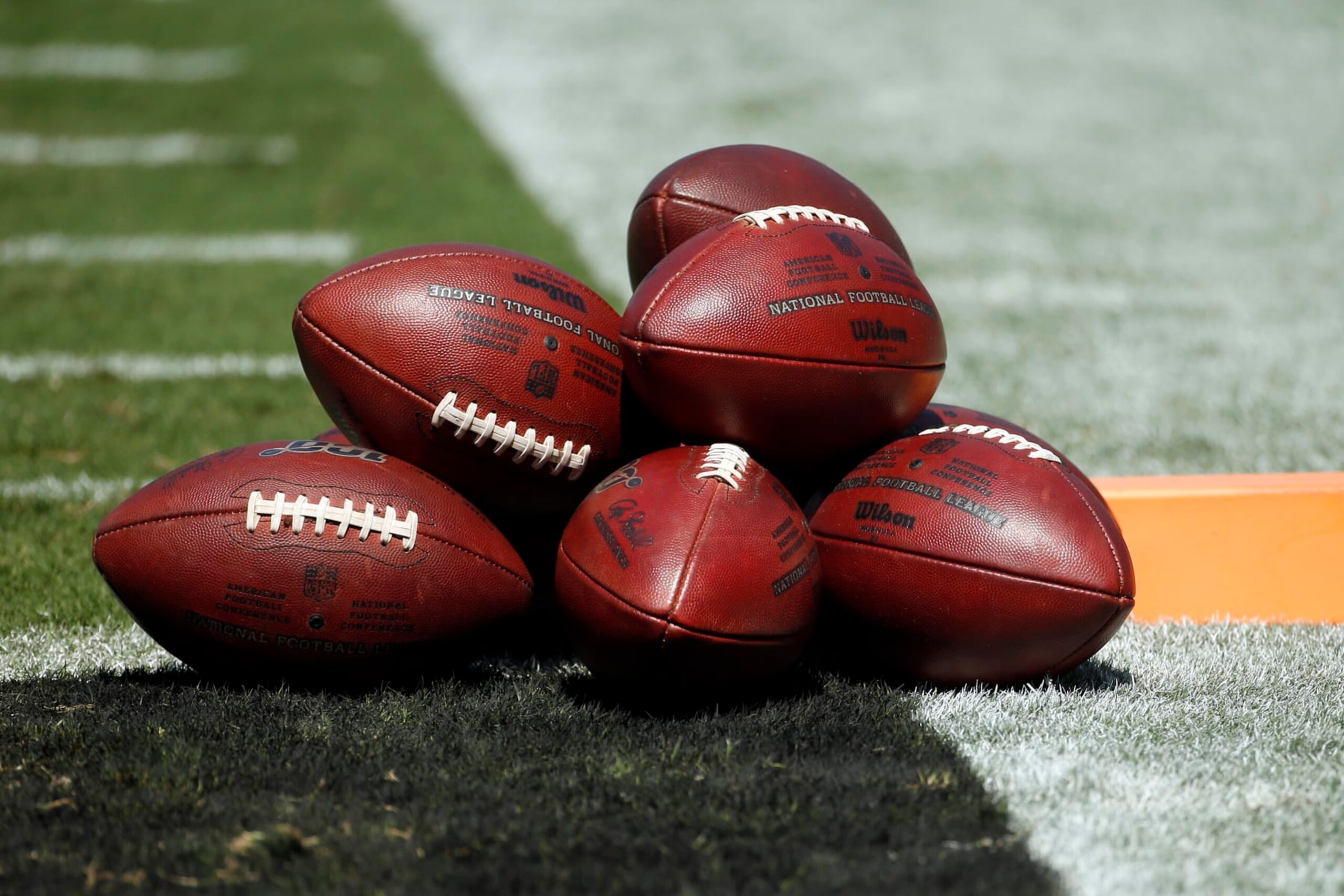 Footballs are piled on the field prior to an NFL football game between the Carlina Panthers and the Los Angeles Rams in Charlotte, N.C., Sunday, Sept. 8, 2019. (AP Photo/Brian Blanco)