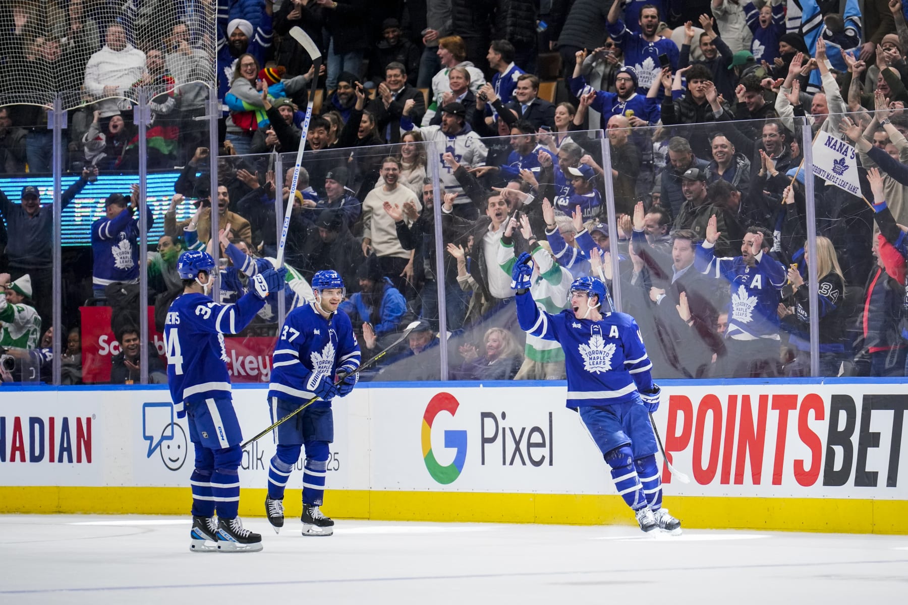 TORONTO, ON - JANUARY 25: Mitchell Marner #16 of the Toronto Maple Leafs celebrates his game winning goal against the New York Rangers with team-mates Timothy Liljegren #37  and Auston Matthews #34 at the Scotiabank Arena on January 25, 2023 in Toronto, Ontario, Canada. (Photo by Andrew Lahodynskyj/NHLI via Getty Images)