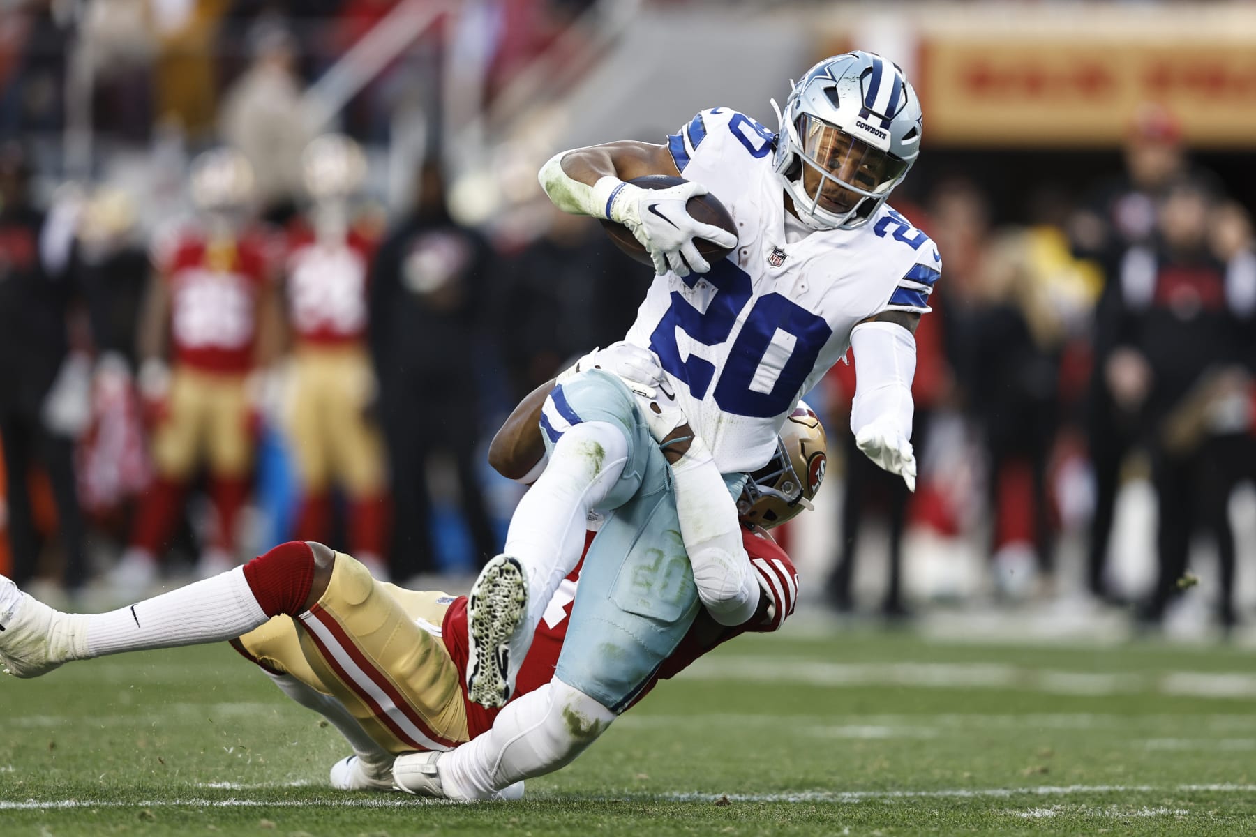 SANTA CLARA, CALIFORNIA - JANUARY 22: Tony Pollard #20 of the Dallas Cowboys is tackled by Jimmie Ward #1 of the San Francisco 49ers as he runs with the ball and gets injured during an NFL divisional round playoff football game between the San Francisco 49ers and the Dallas Cowboys at Levi's Stadium on January 22, 2023 in Santa Clara, California. (Photo by Michael Owens/Getty Images)