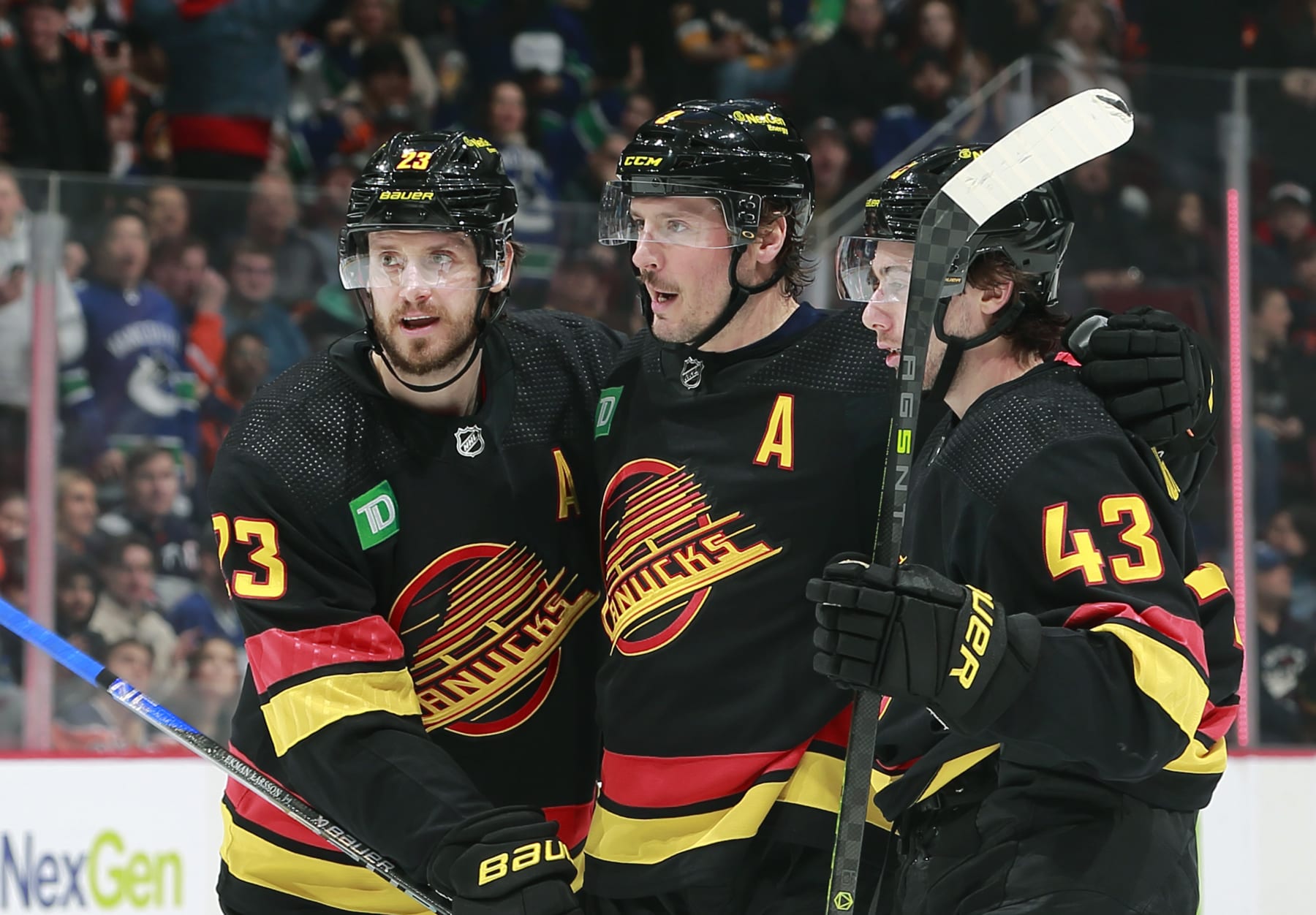 VANCOUVER, CANADA - JANUARY 21: J.T. Miller #9 of the Vancouver Canucks is congratulated by teammates Oliver Ekman-Larsson #23 and Quinn Hughes #43 after scoring during their NHL game against the Edmonton Oilers at Rogers Arena January 21, 2023 in Vancouver, British Columbia, Canada.  (Photo by Jeff Vinnick/NHLI via Getty Images)