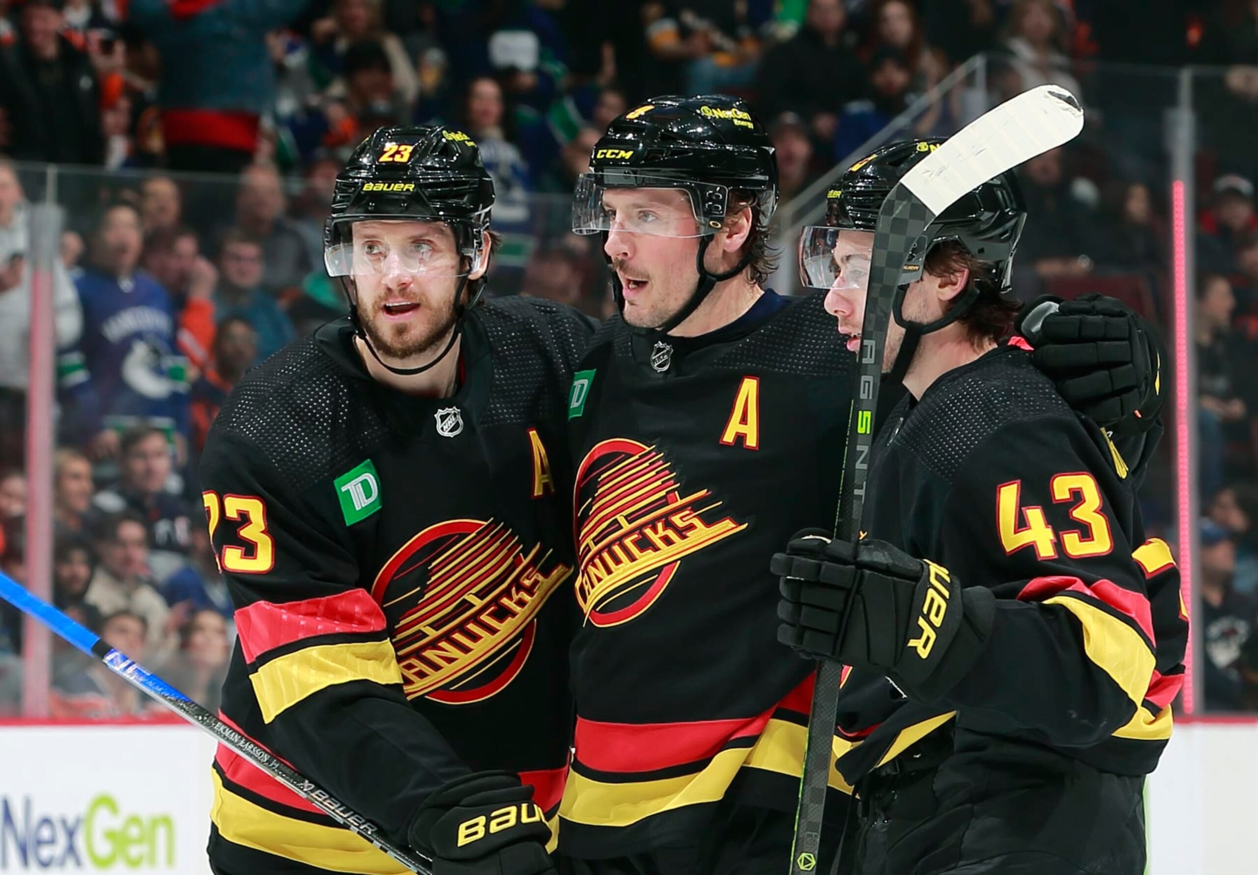 VANCOUVER, CANADA - JANUARY 21: J.T. Miller #9 of the Vancouver Canucks is congratulated by teammates Oliver Ekman-Larsson #23 and Quinn Hughes #43 after scoring during their NHL game against the Edmonton Oilers at Rogers Arena January 21, 2023 in Vancouver, British Columbia, Canada.  (Photo by Jeff Vinnick/NHLI via Getty Images)