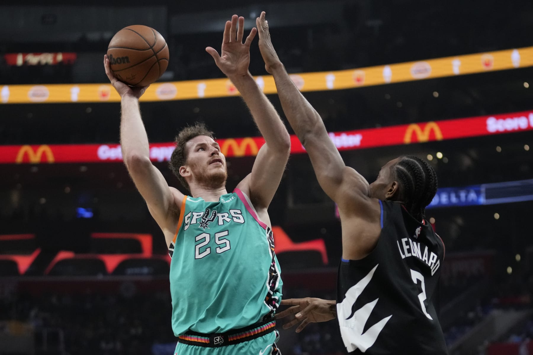 San Antonio Spurs center Jakob Poeltl (25) shoots against Los Angeles Clippers forward Kawhi Leonard (2) during the first half of an NBA basketball game in Los Angeles, Thursday, Jan. 26, 2023. (AP Photo/Ashley Landis)
