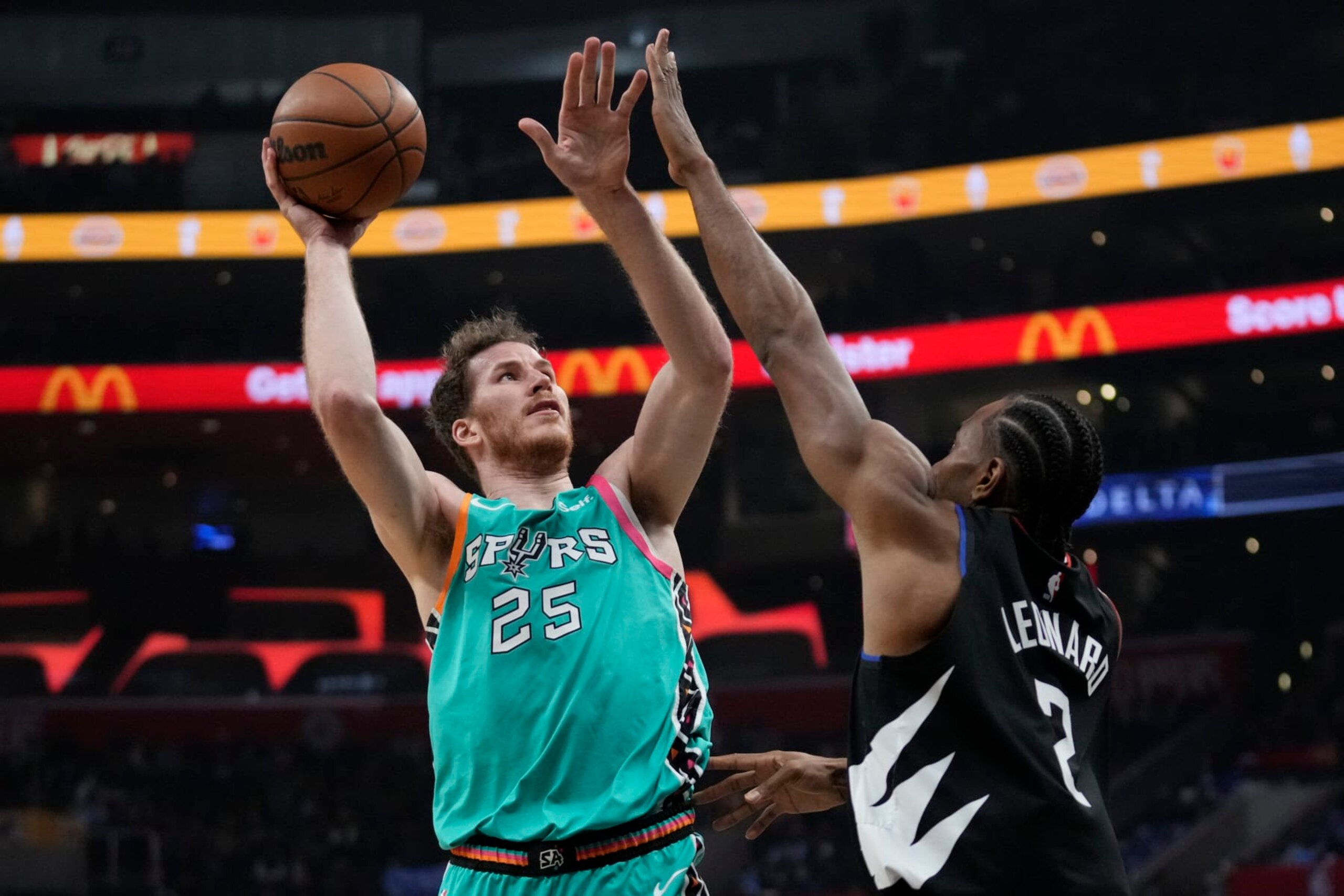 San Antonio Spurs center Jakob Poeltl (25) shoots against Los Angeles Clippers forward Kawhi Leonard (2) during the first half of an NBA basketball game in Los Angeles, Thursday, Jan. 26, 2023. (AP Photo/Ashley Landis)