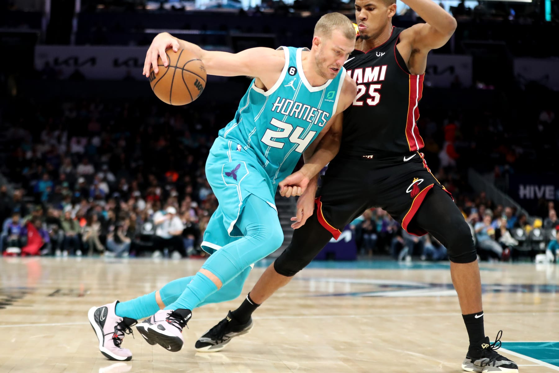 CHARLOTTE, NORTH CAROLINA - JANUARY 29: Mason Plumlee #24 of the Charlotte Hornets drives to the basket while being defended by Orlando Robinson #25 of the Miami Heat during the second quarter of a basketball game at Spectrum Center on January 29, 2023 in Charlotte, North Carolina. NOTE TO USER: User expressly acknowledges and agrees that, by downloading and or using this photograph, User is consenting to the terms and conditions of the Getty Images License Agreement. (Photo by David Jensen/Getty Images)